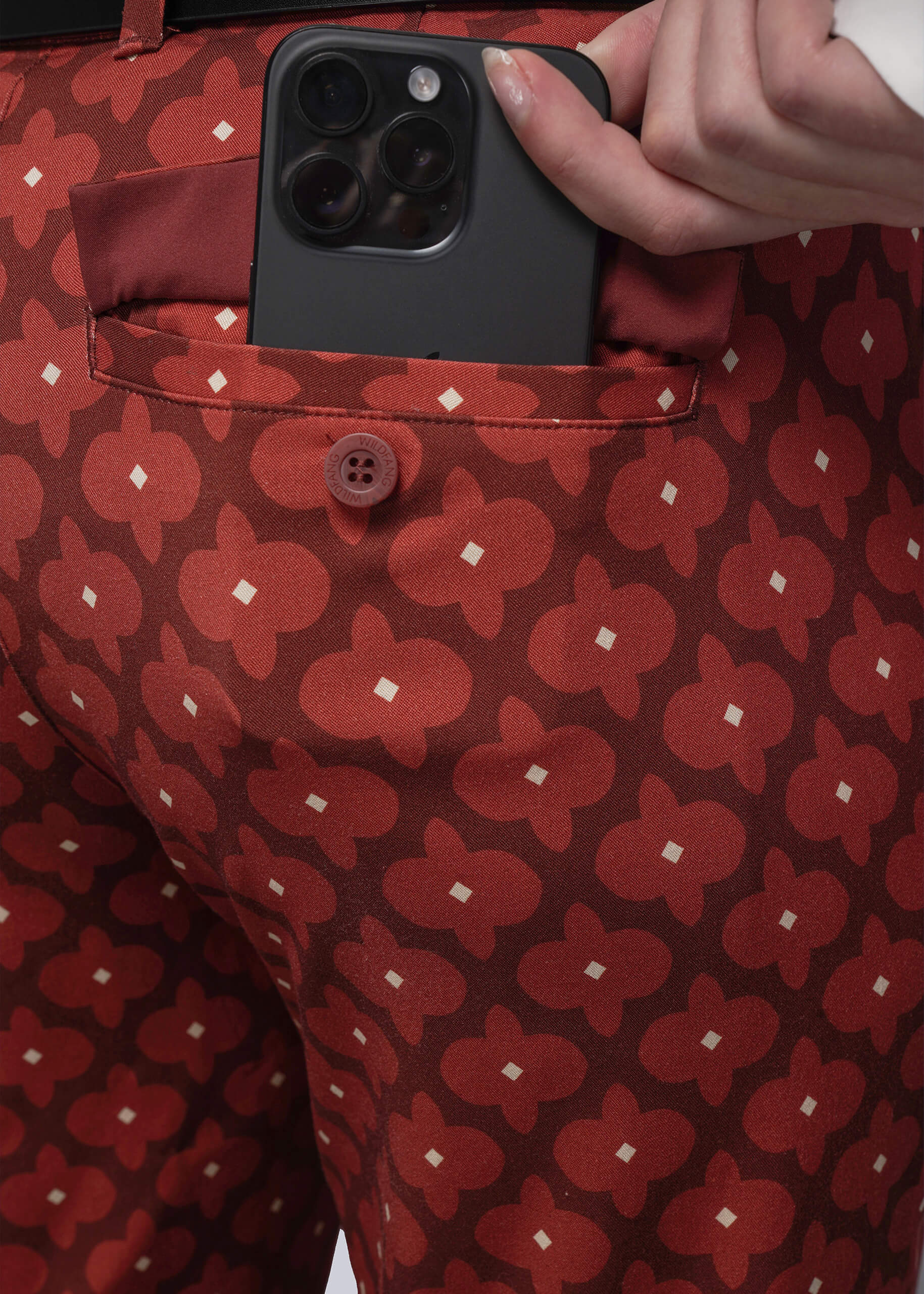 S=Person wearing red patterned pants with a phone in the pocket