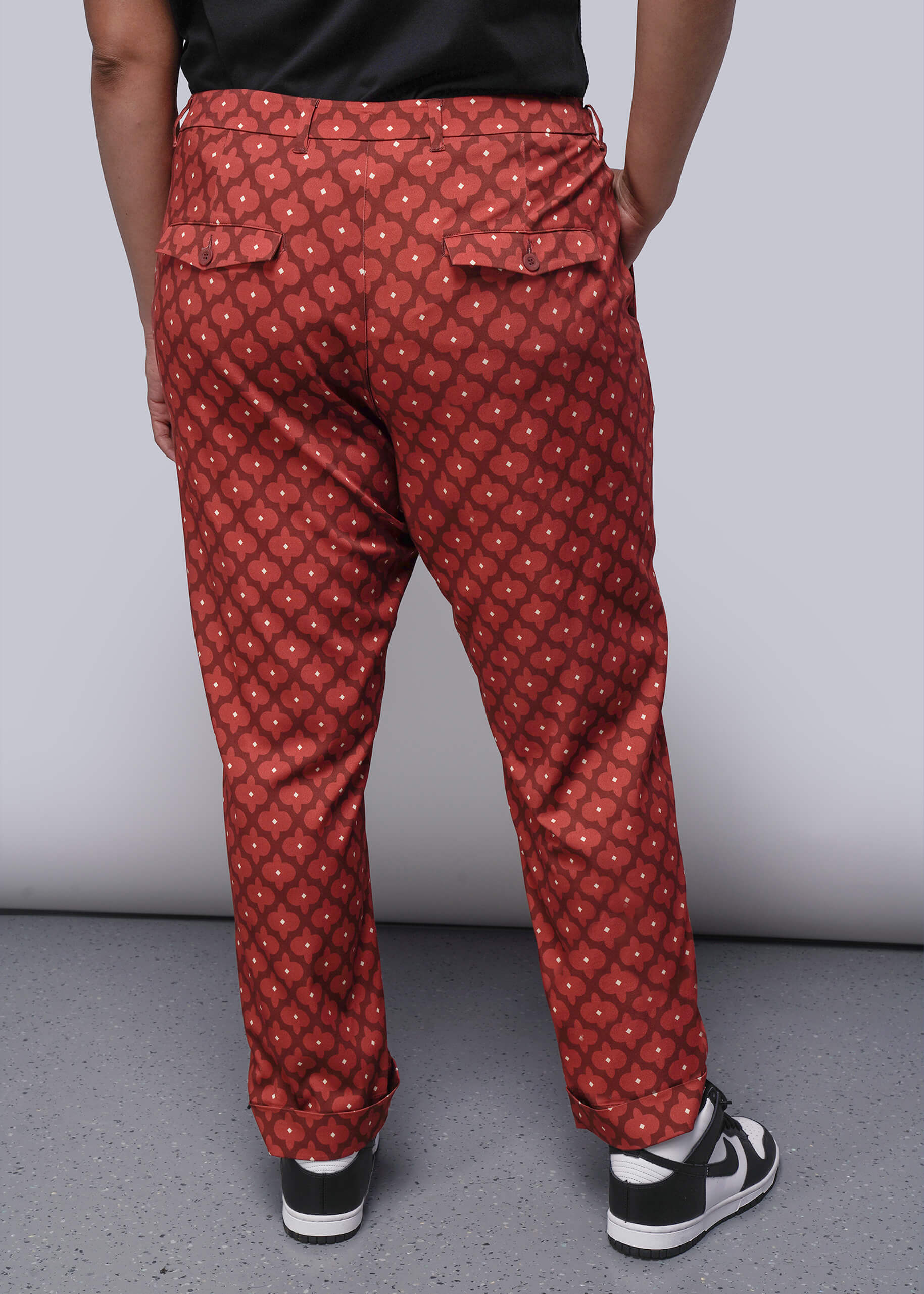1X=Person wearing red patterned pants with a plain background