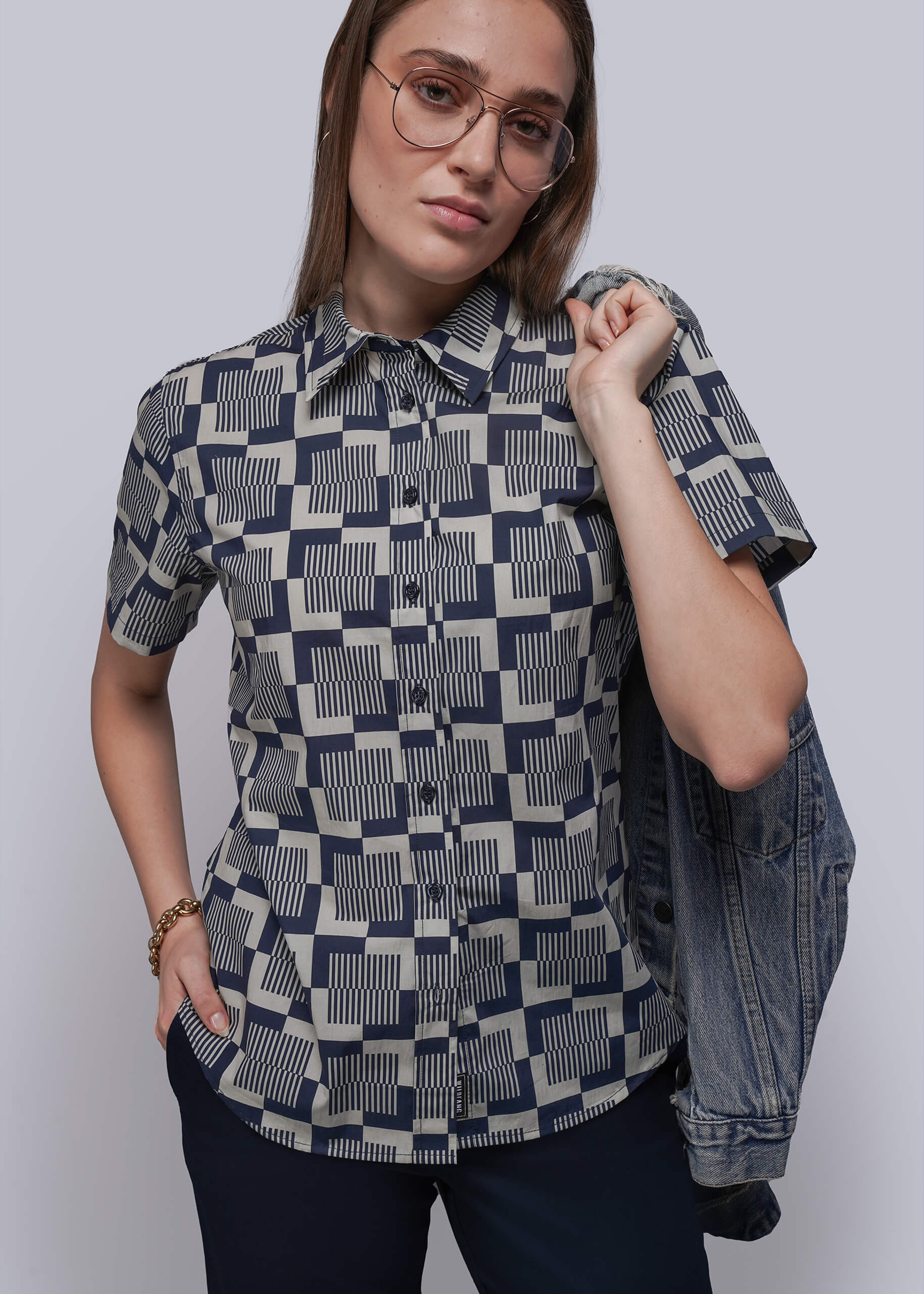 Woman wearing a patterned shirt with a plain background