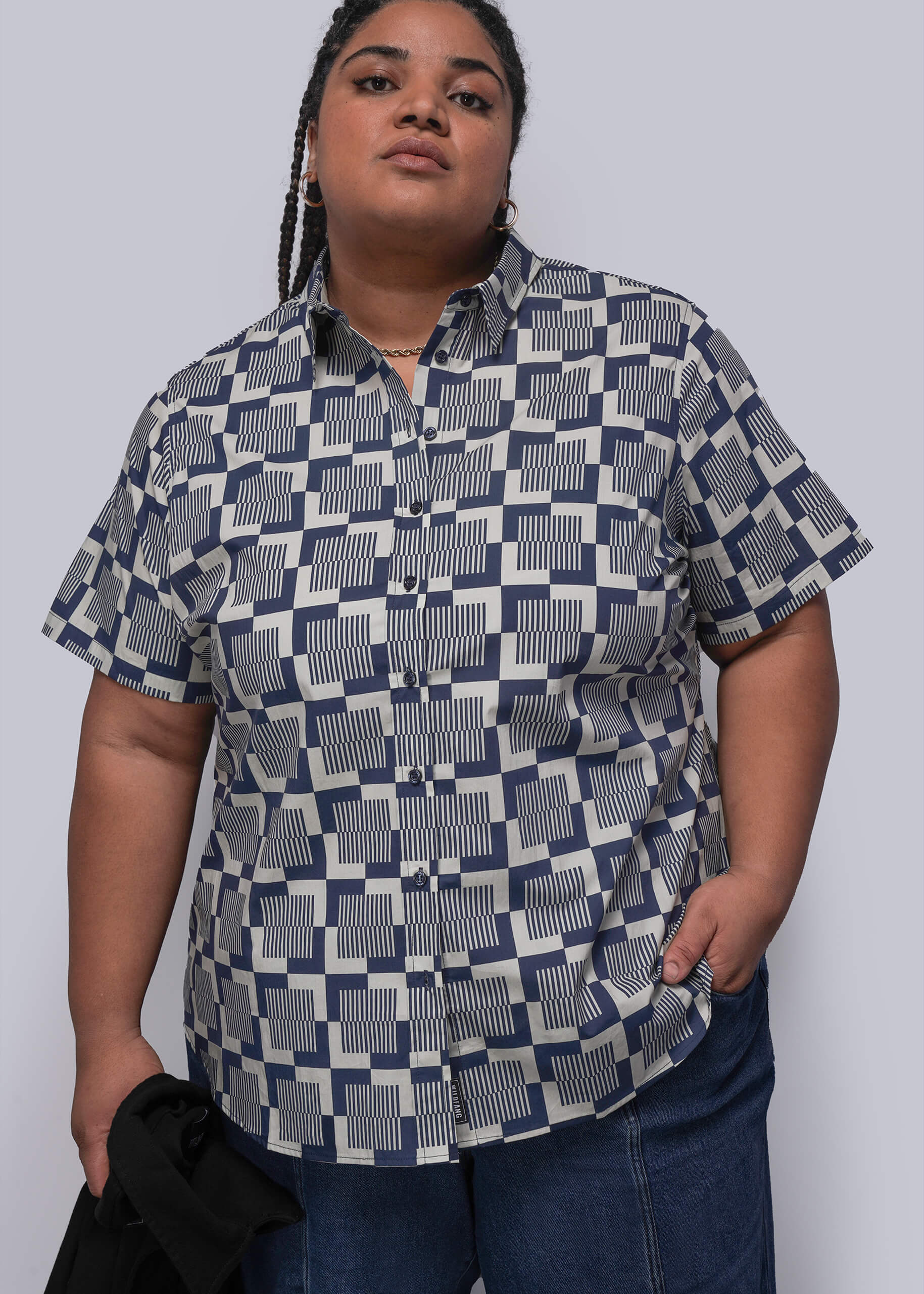 1X=Person wearing a patterned shirt with a plain background