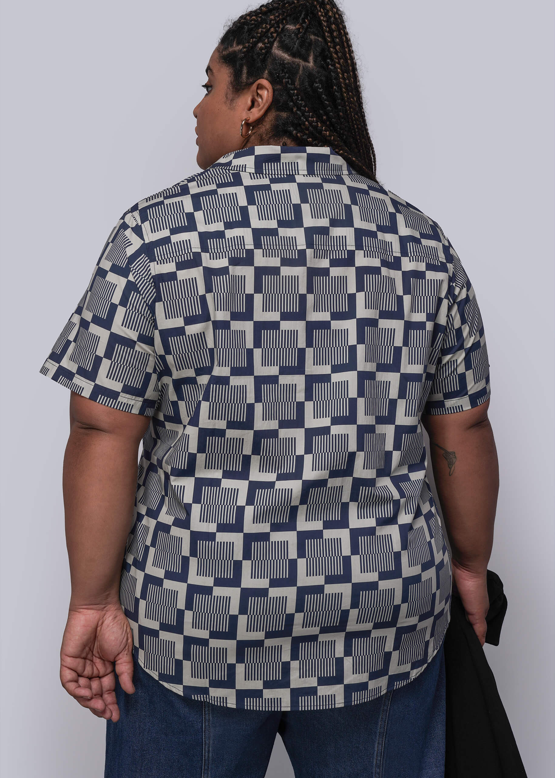 1X=Person wearing a patterned shirt with a plain background