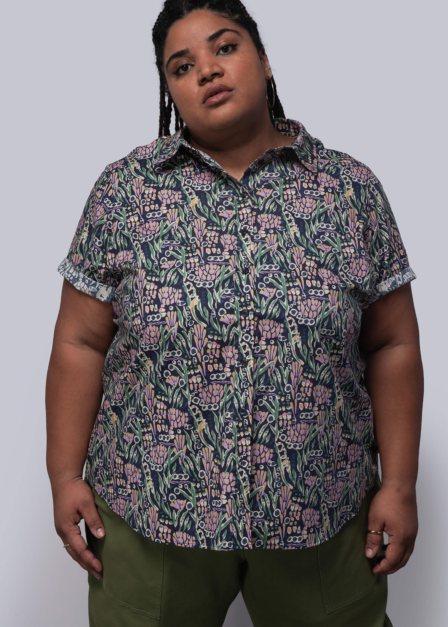 1X=Person wearing a patterned shirt with a plain background