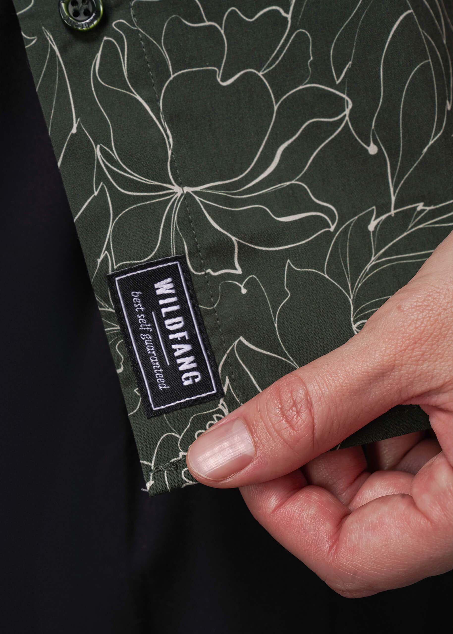 S=Hand holding a green fabric with floral pattern and Wildfang label.
