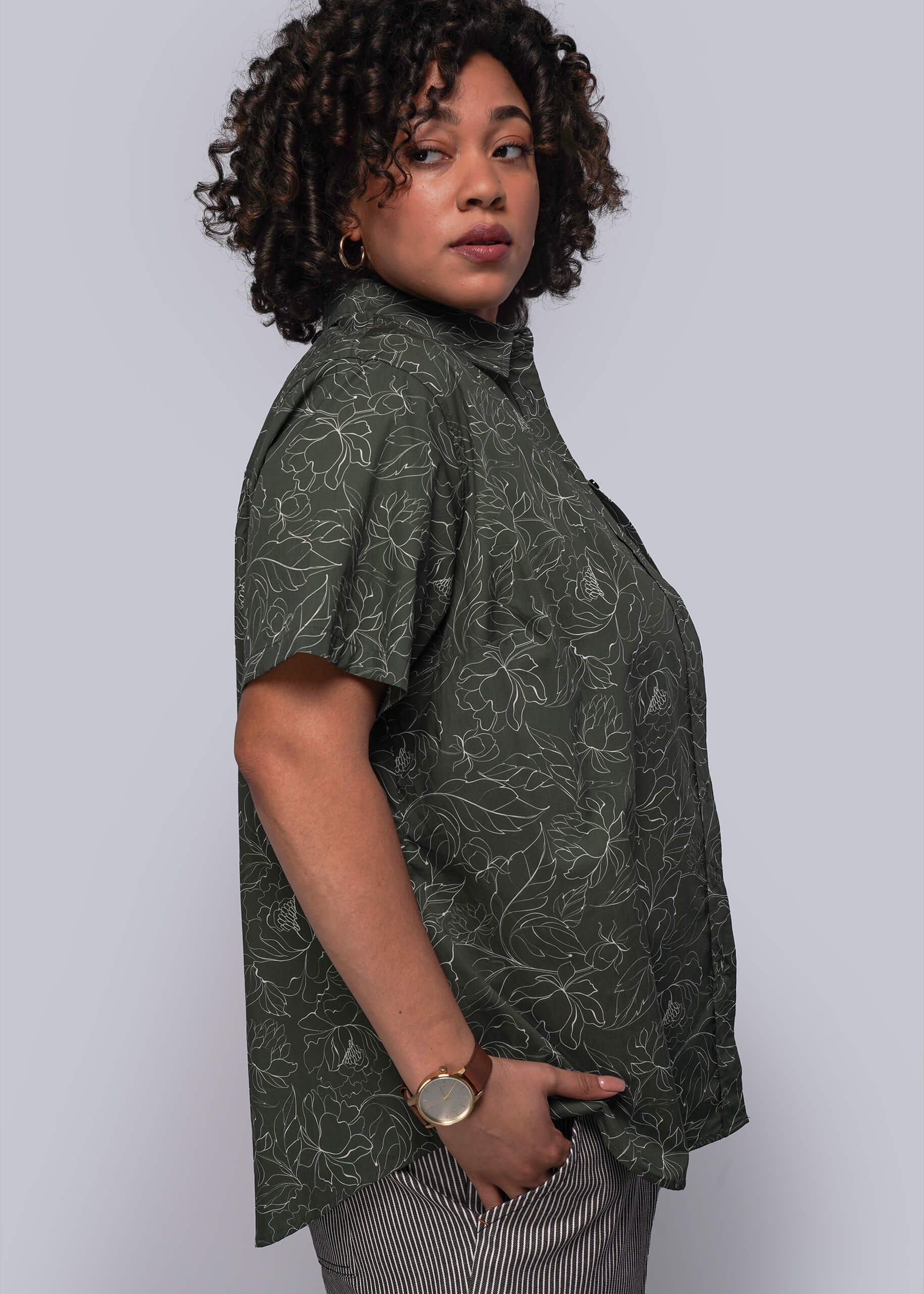 1X=Person wearing a dark green patterned shirt against a plain background