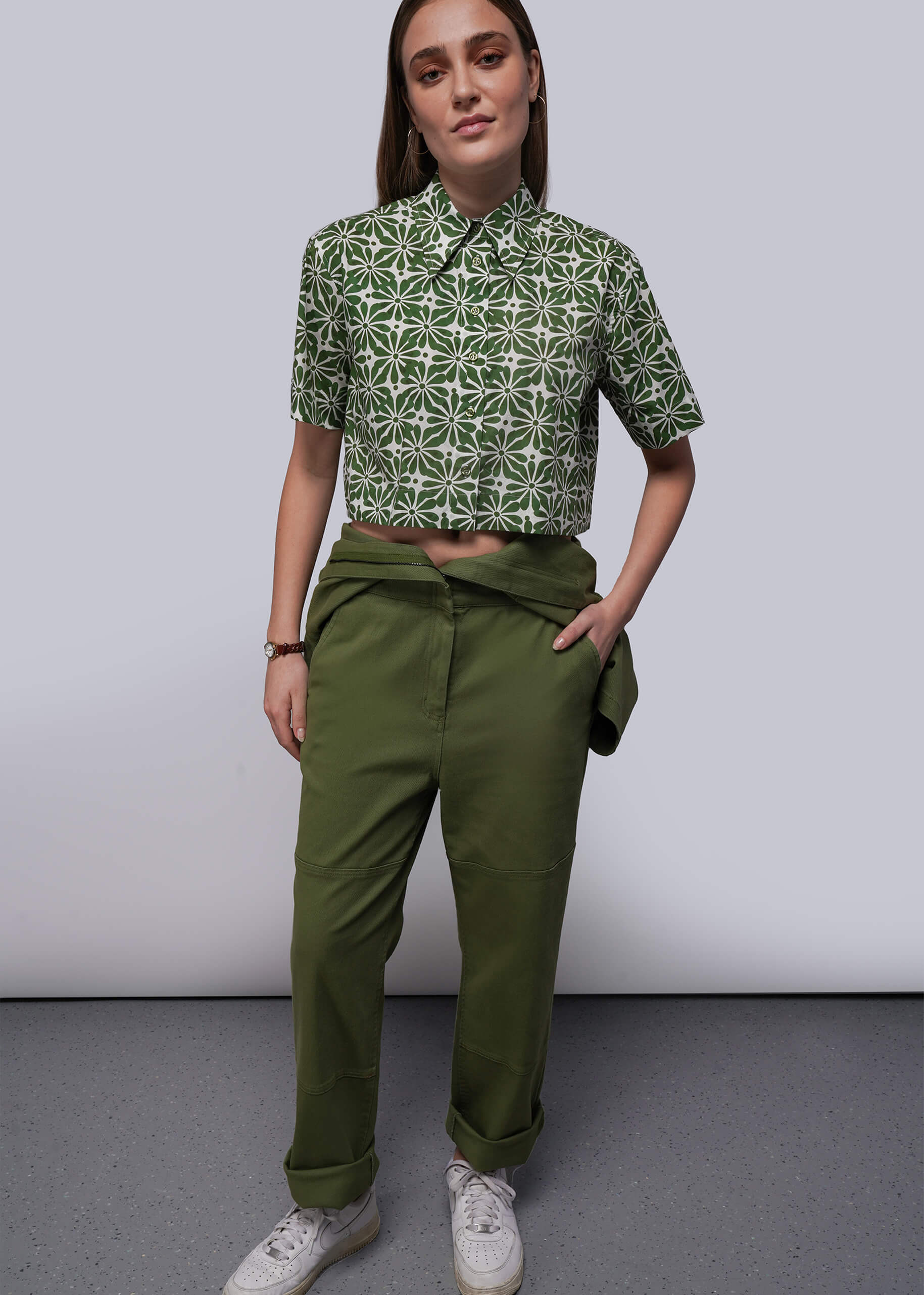 S=Person wearing a green patterned shirt and green pants against a plain background