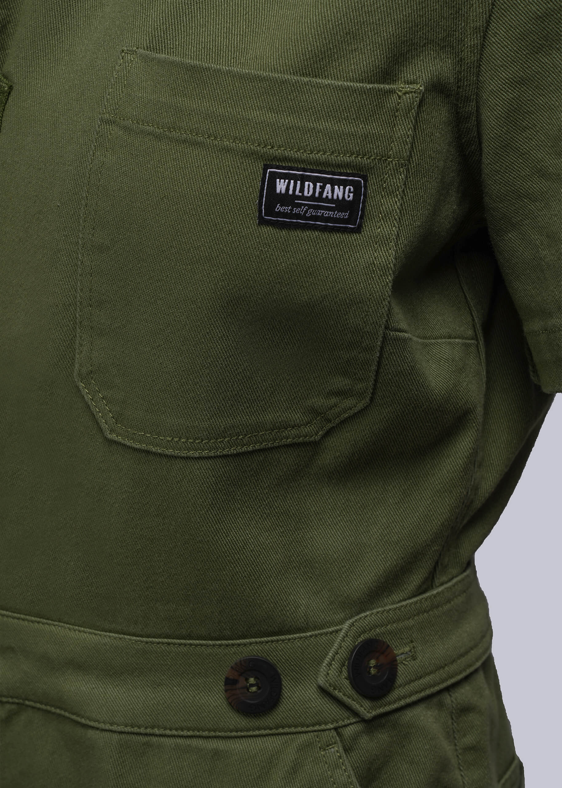 1X=Green coverall pocket with a 'Wildfang' label on a white background