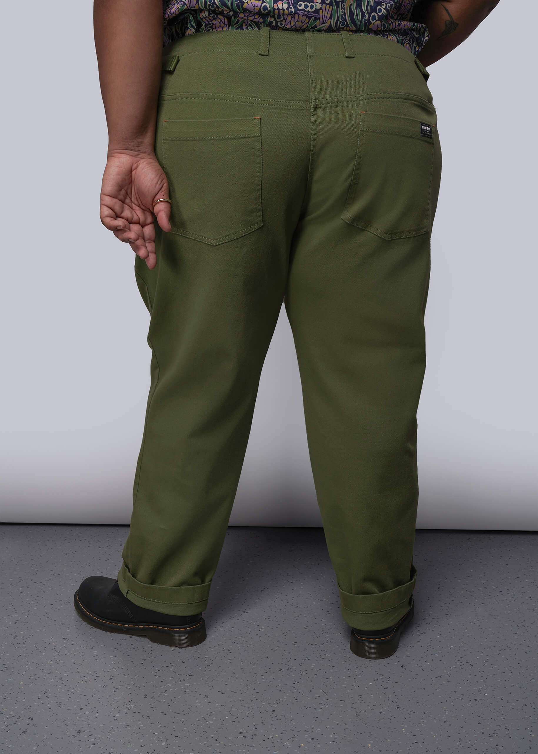1X=Person wearing olive green pants on a plain background