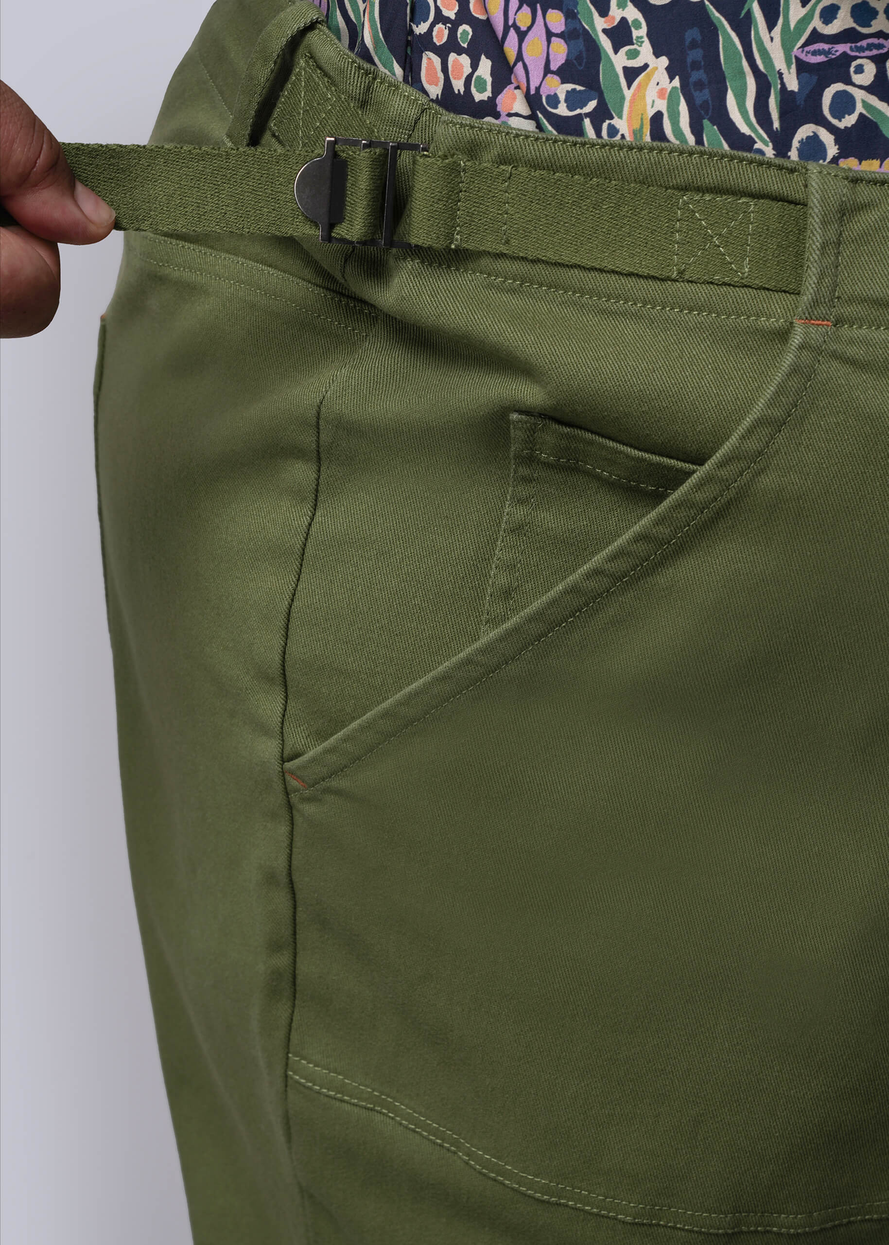 1X=Close-up of green pants waist and pocket on a white background