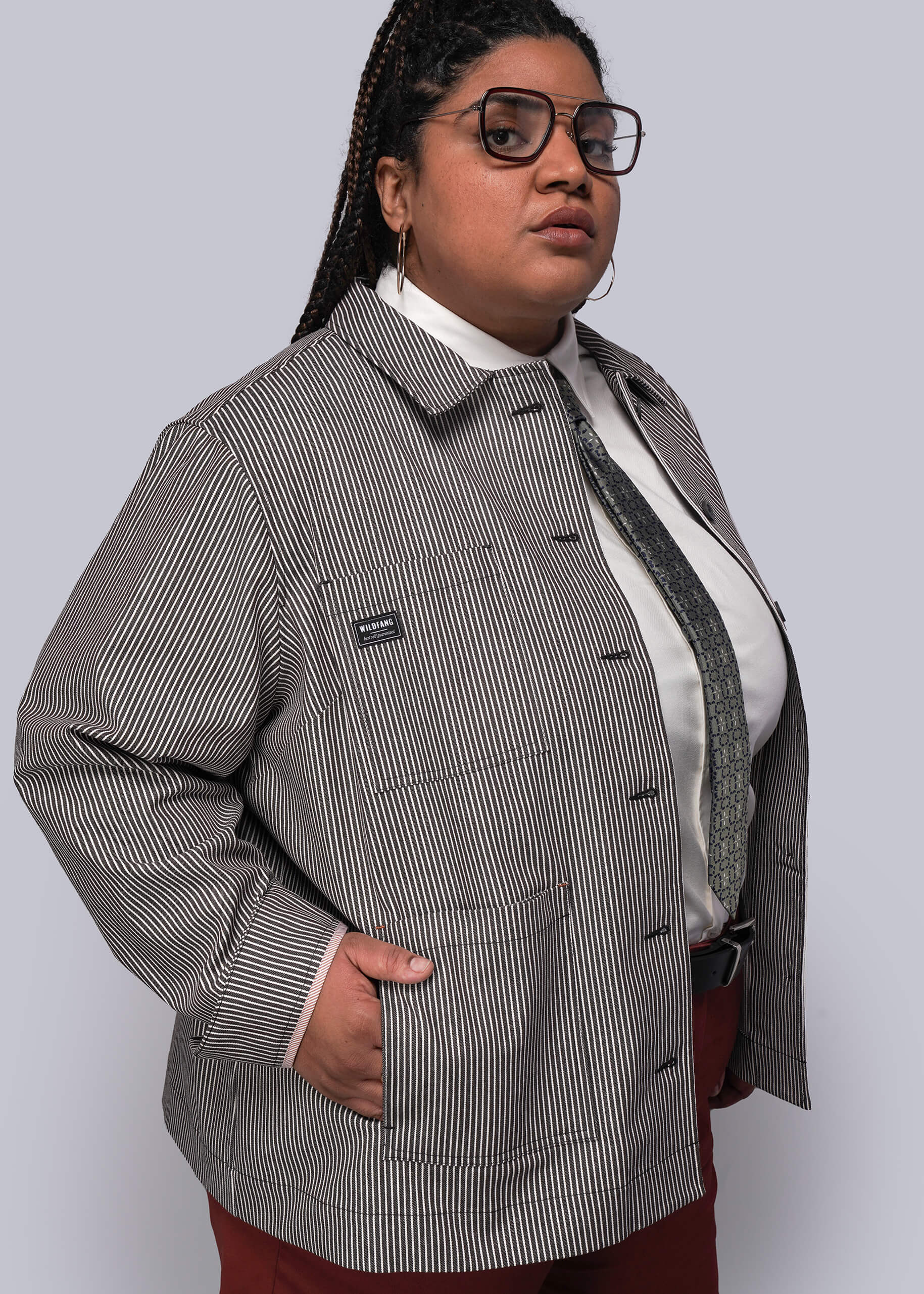 1X=Person wearing a brown and white striped jacket over a white shirt on a plain background