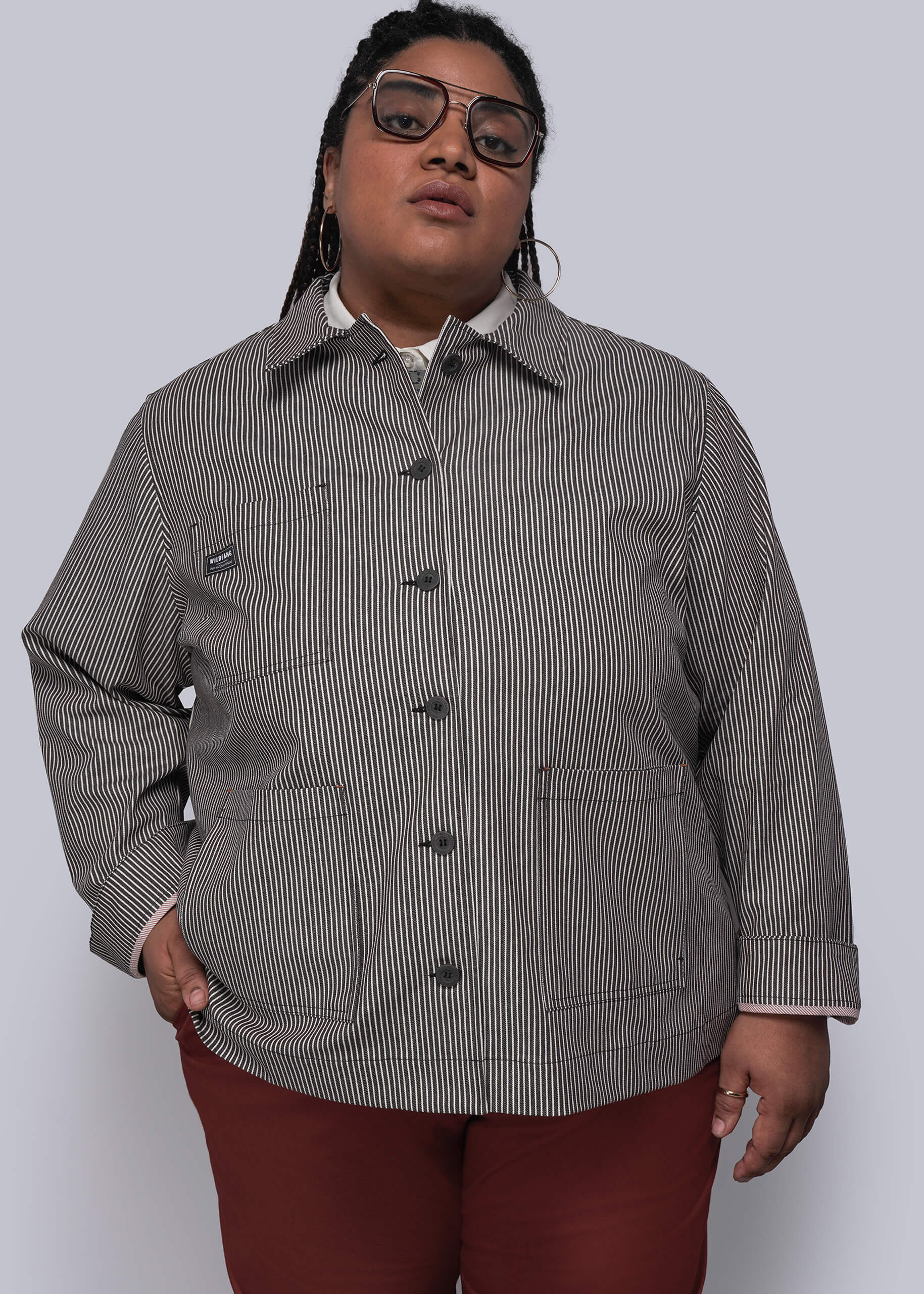 1X=Person wearing a brown and white striped jacket with black buttons on a white background