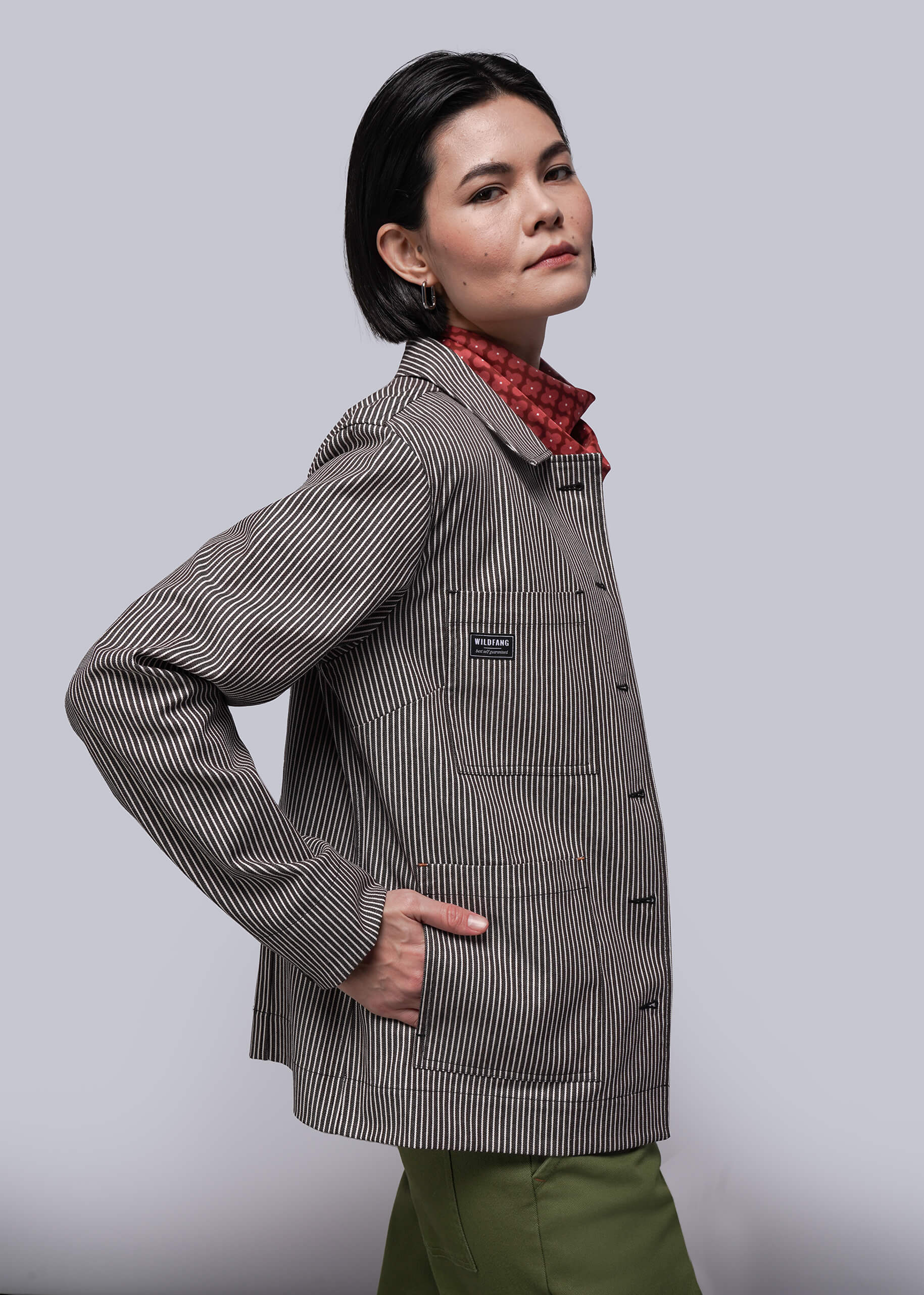 S=Person wearing a brown and white striped jacket with a visible brand logo on a light gray background