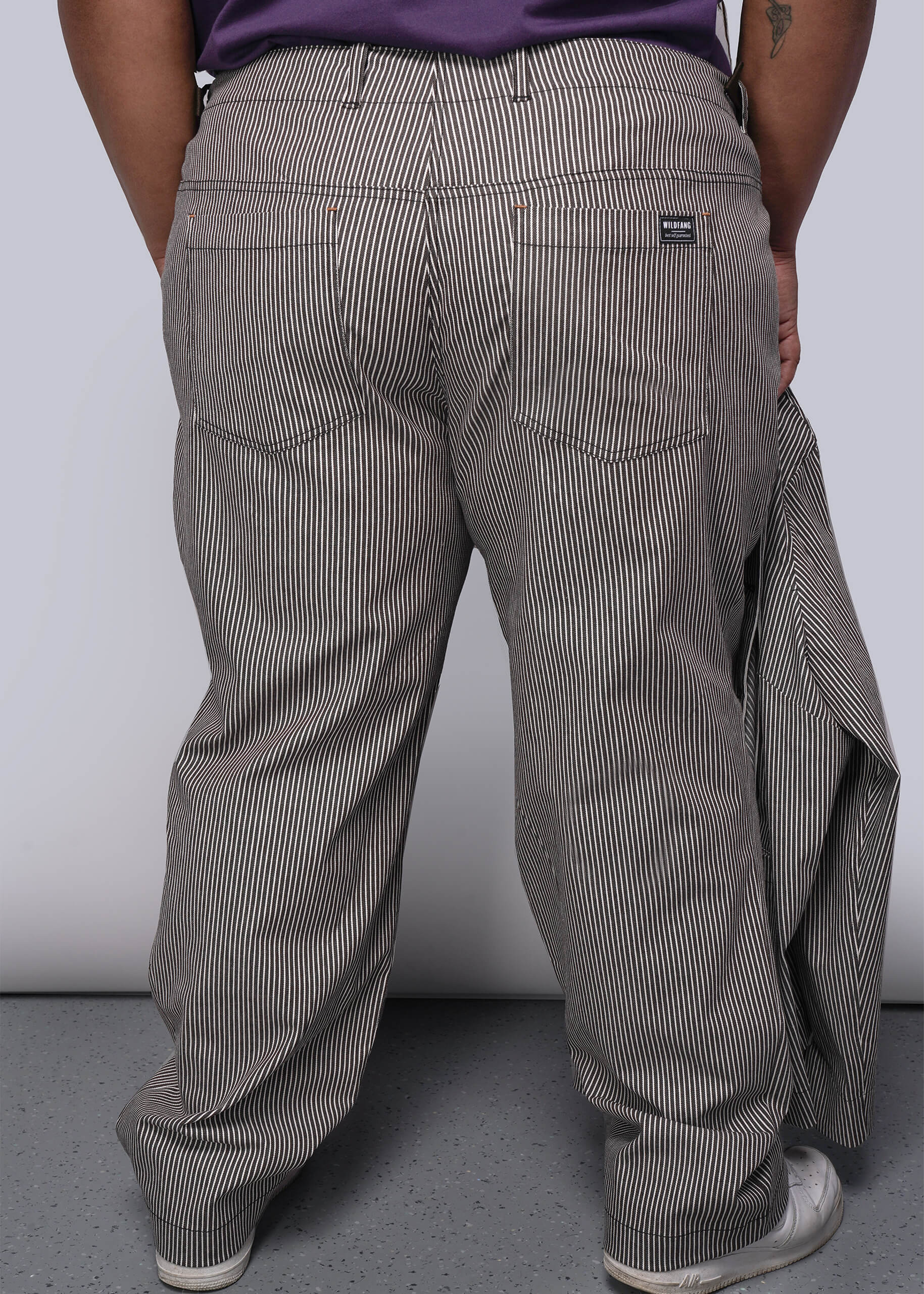 1X=Person wearing brown and white striped pants with a white background