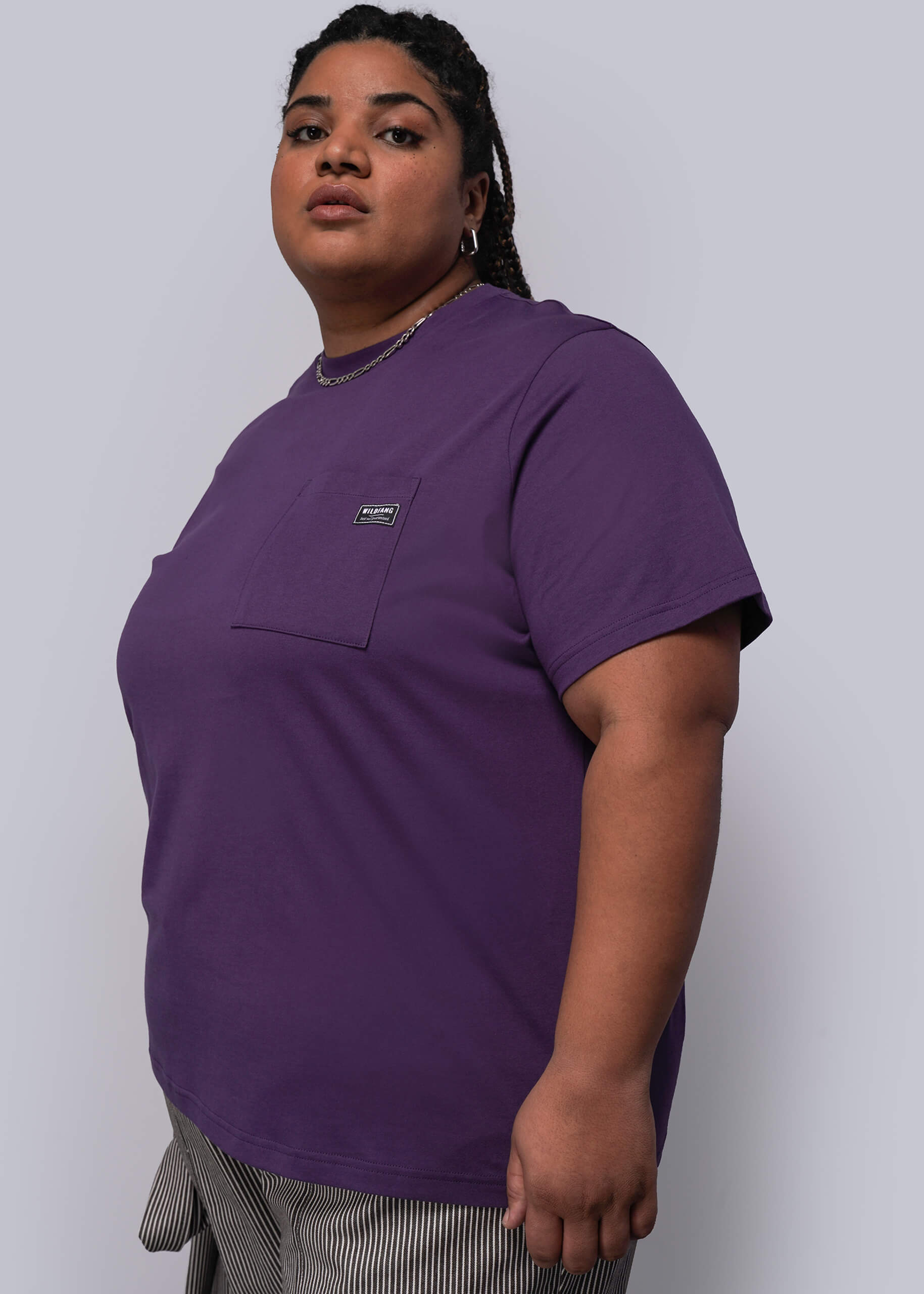 1X=Person wearing a purple t-shirt against a plain background