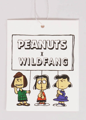 1X=Hang tag laying flat on white background printed with Peanuts characters Peppermint Patty, Marcie, and Lucy holding sign that has the PEANUTS X WILDFANG logo on it.