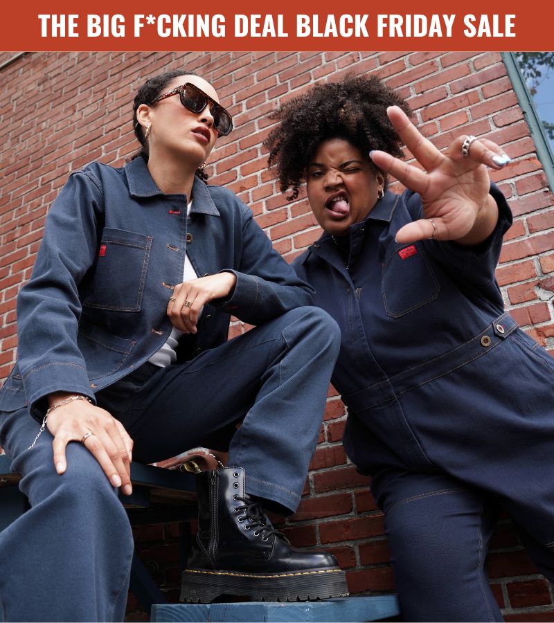 Two people wearing blue denim workwear stand in front of brick wall posing. Promotional text in red banner above image reads THE BIG F*CKING DEAL BLACK FRIDAY SALE.