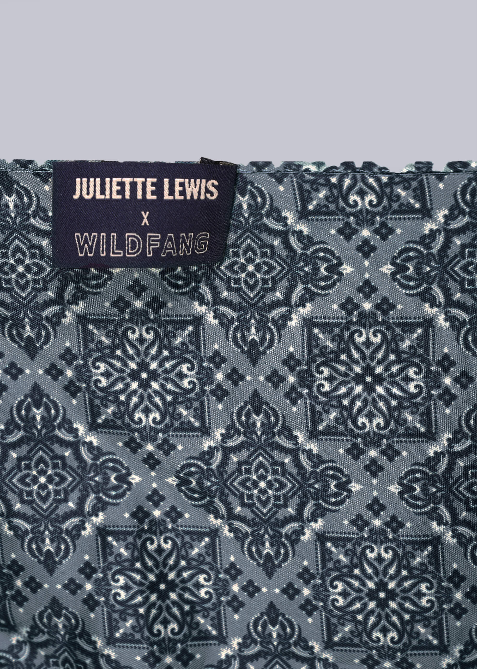 Patterned fabric with 'Juliette Lewis x Wildfang' label on a gray background