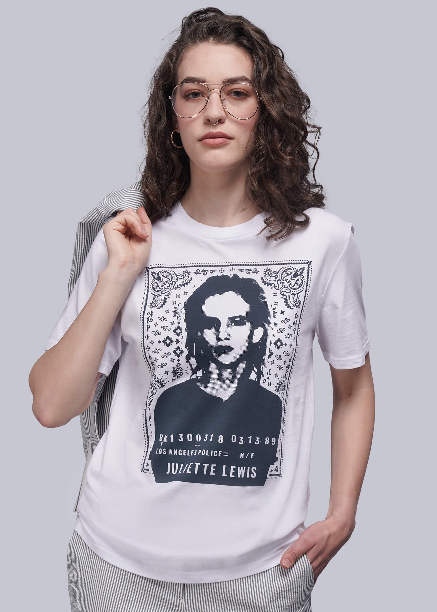 Person wearing a white t-shirt with a graphic design on a plain background