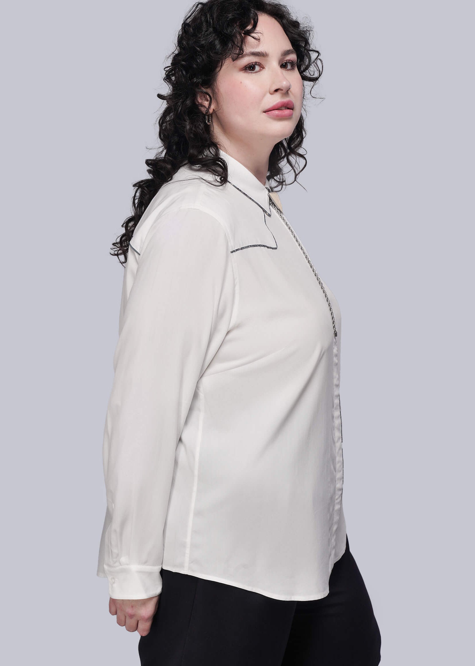 1X=Person wearing a white button up shirt and black shorts on a light gray background