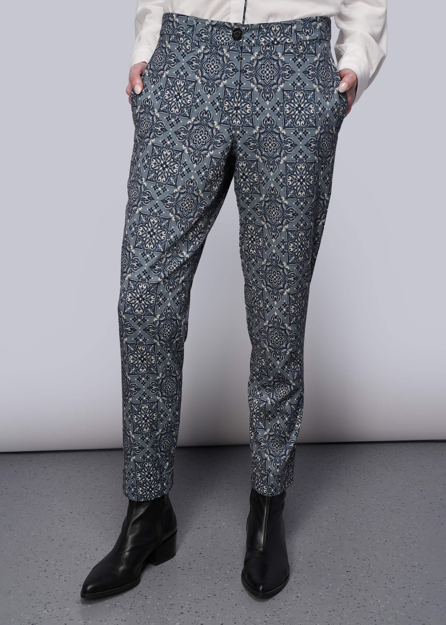 S=From waist down, person wearing patterned pants and black shoes on a plain background