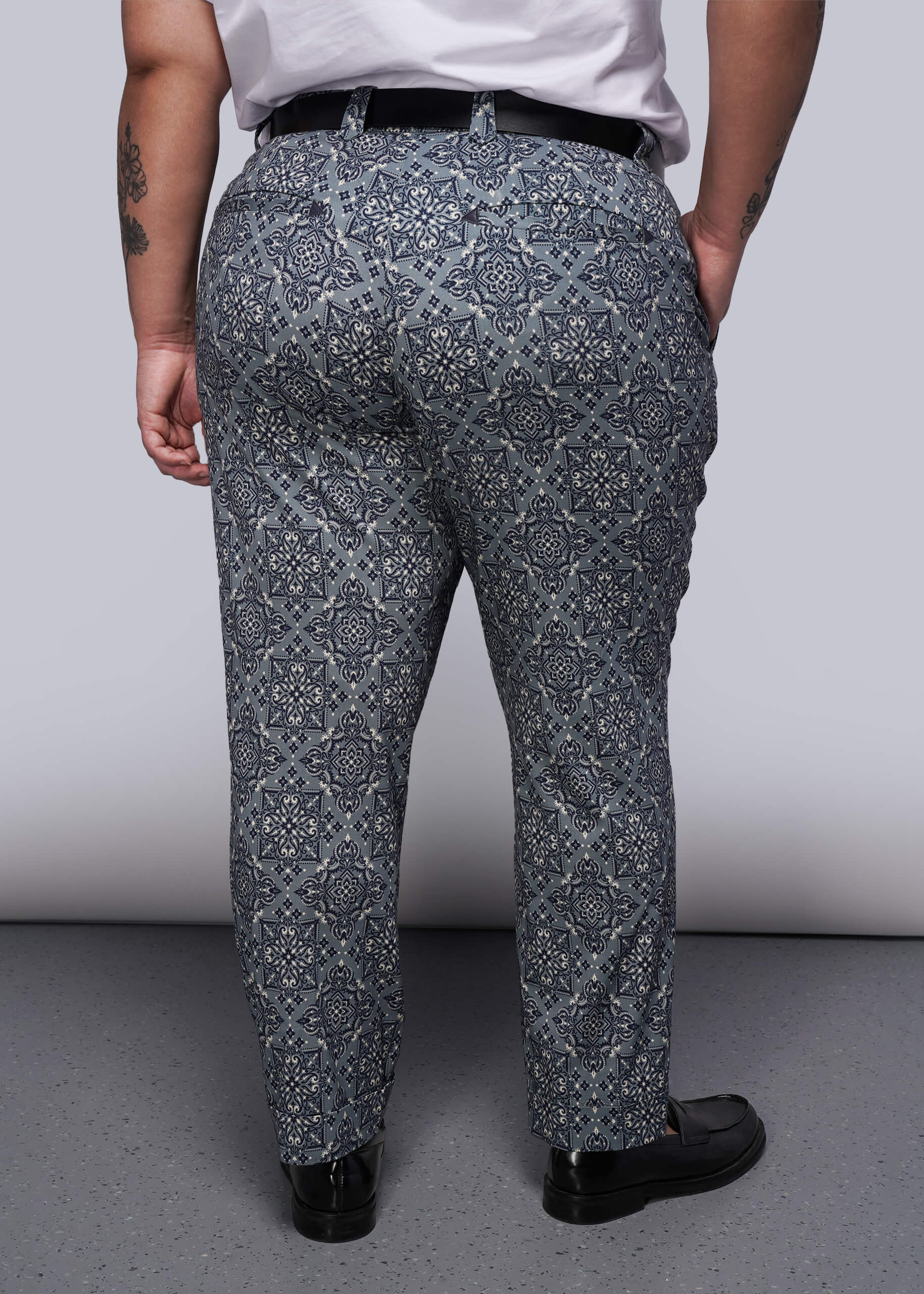 1X=From waist down, person wearing patterned teal pants with a plain background