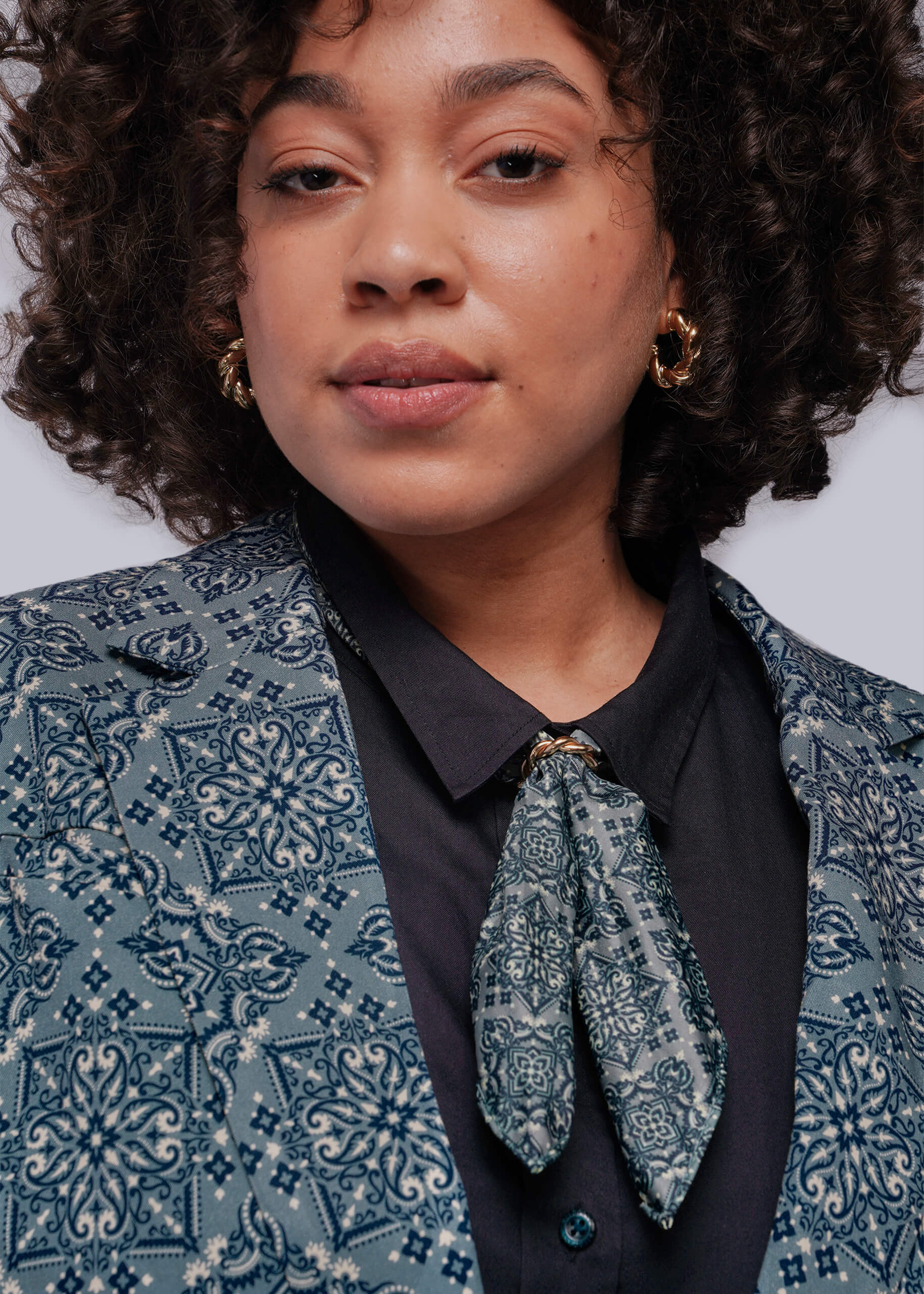 Person wearing a patterned blazer with a white background