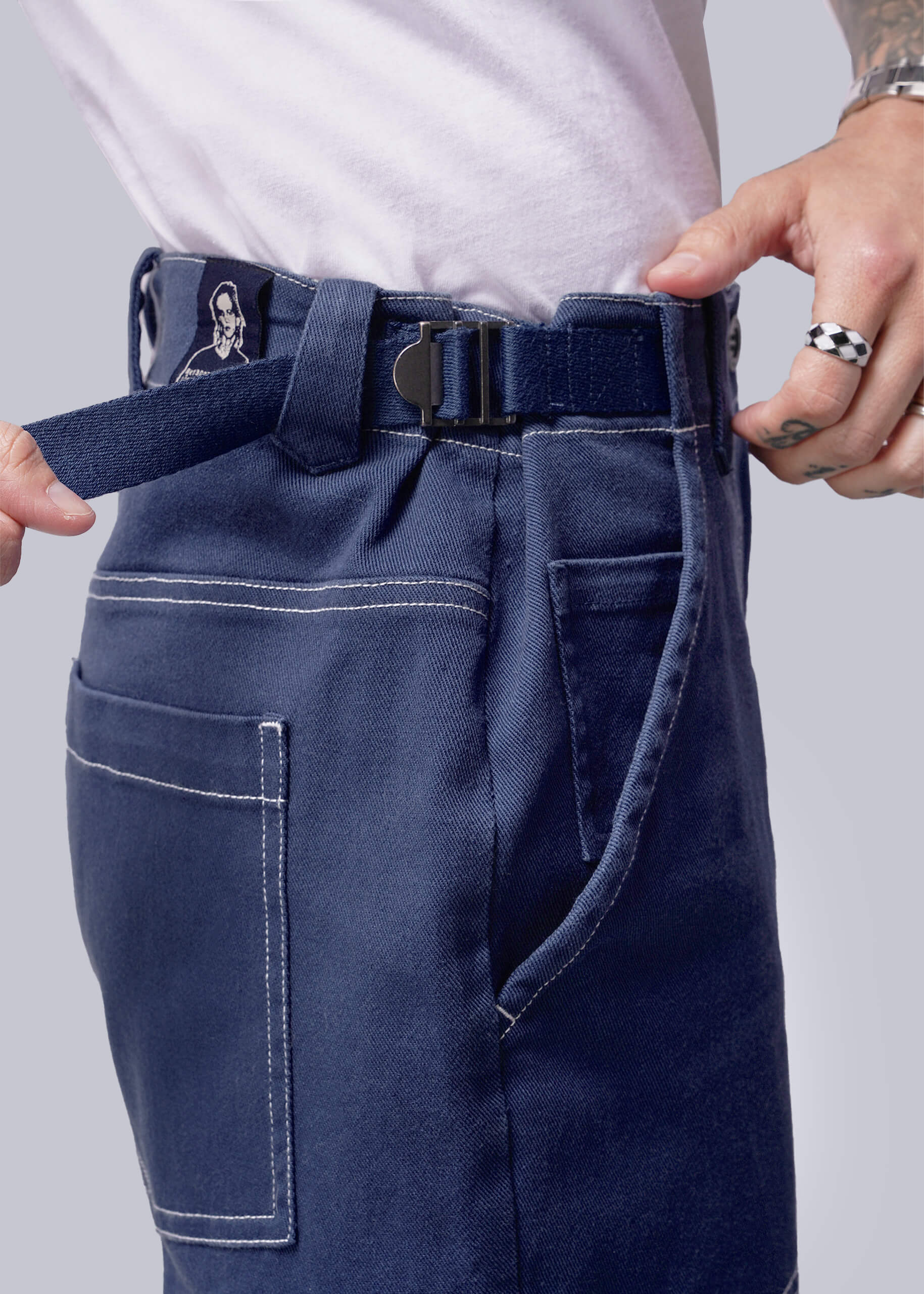 S=Close up of waistband of denim pant showing adjustable buckle