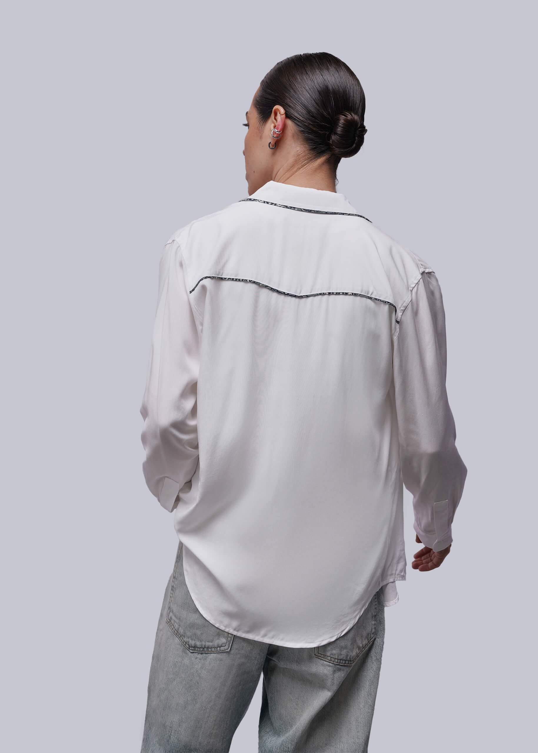 S=Back of person wearing a white shirt and pants on a plain background