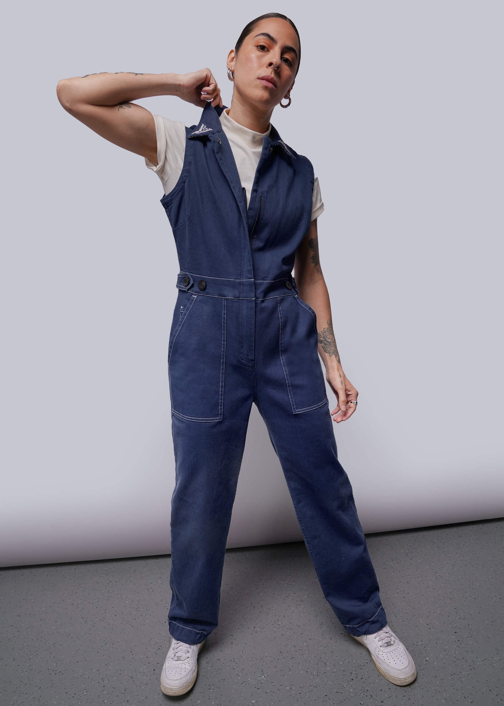 Person wearing a blue denim jumpsuit against a plain background