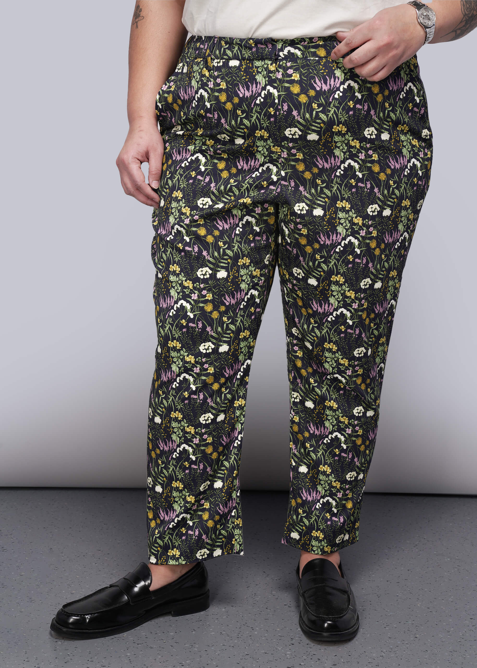 1X=Person wearing floral-patterned pants on a plain background