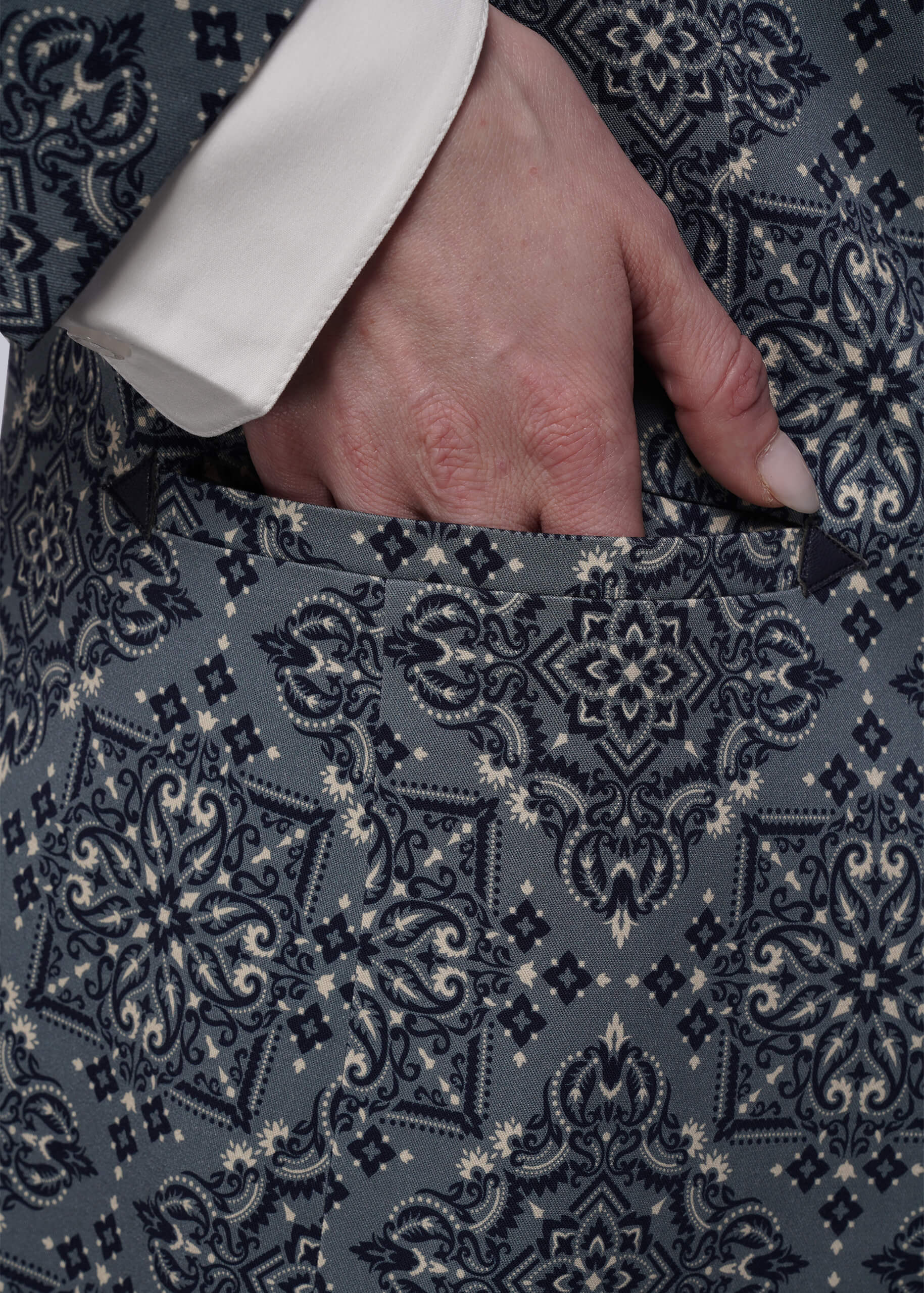 S=Close-up of a hand in a patterened blazer pocket