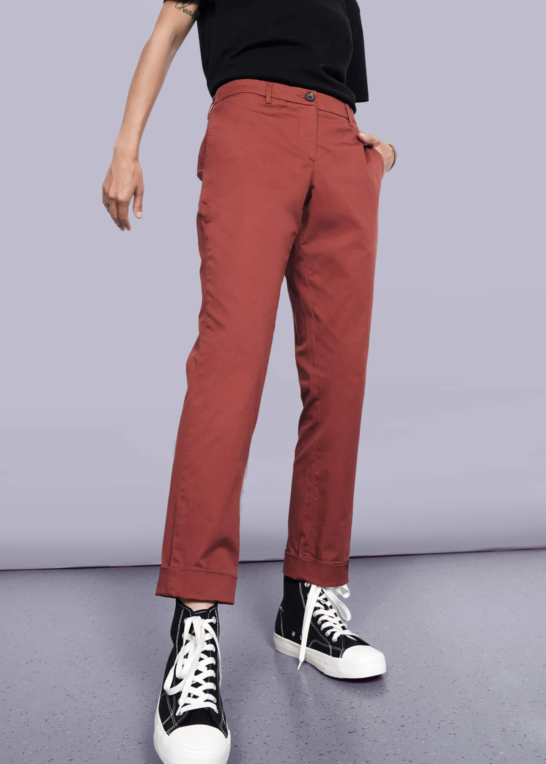 Pictured from the waist down, model wears The Essential Trouser in Cinnamon against a neutral background.