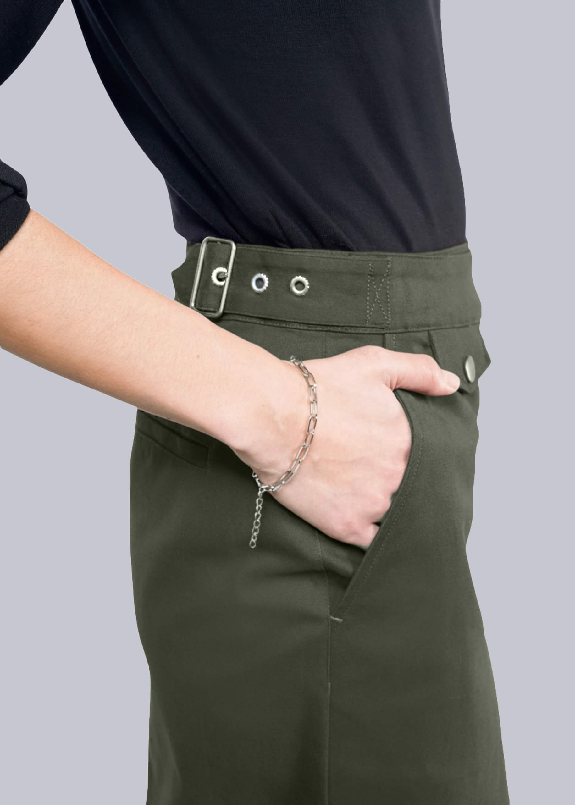 S=Person wearing green skirt with a black top on a gray background