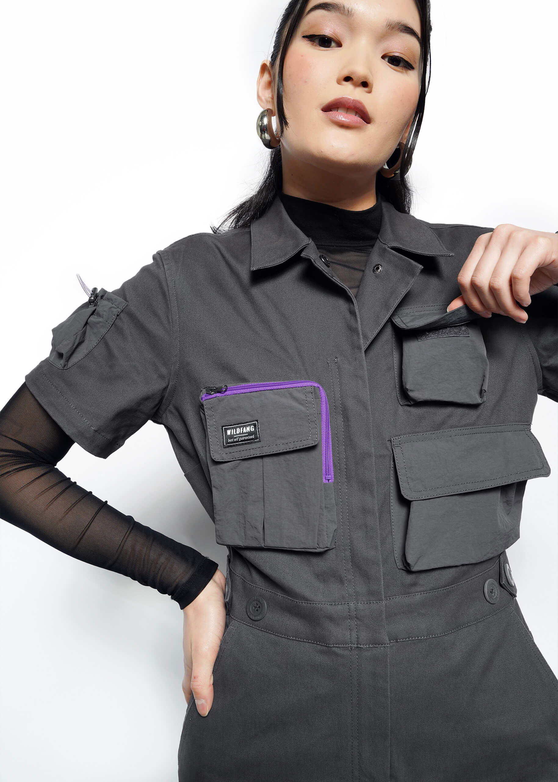 Detailed front view of model wearing slate grey limited edition TACO BELL® x Wildfang short sleeve coveralls 