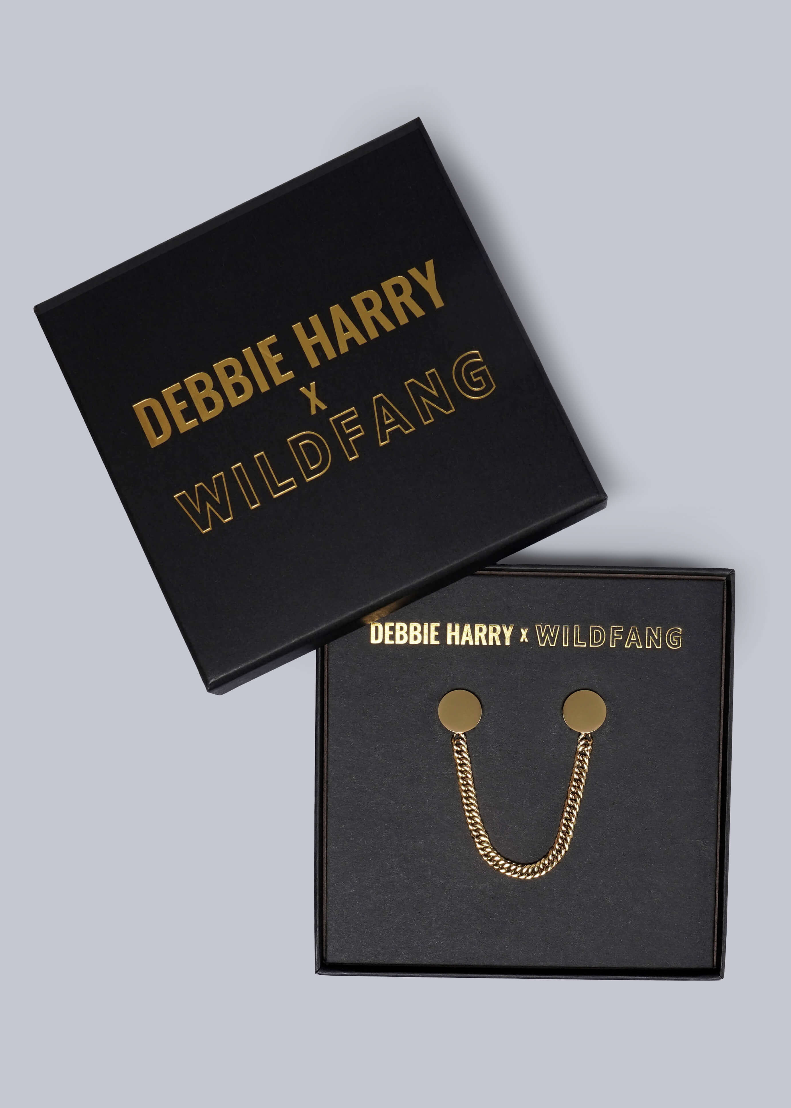Gold collar clips in a 'Debbie Harry x Wildfang' branded box on a gray background
