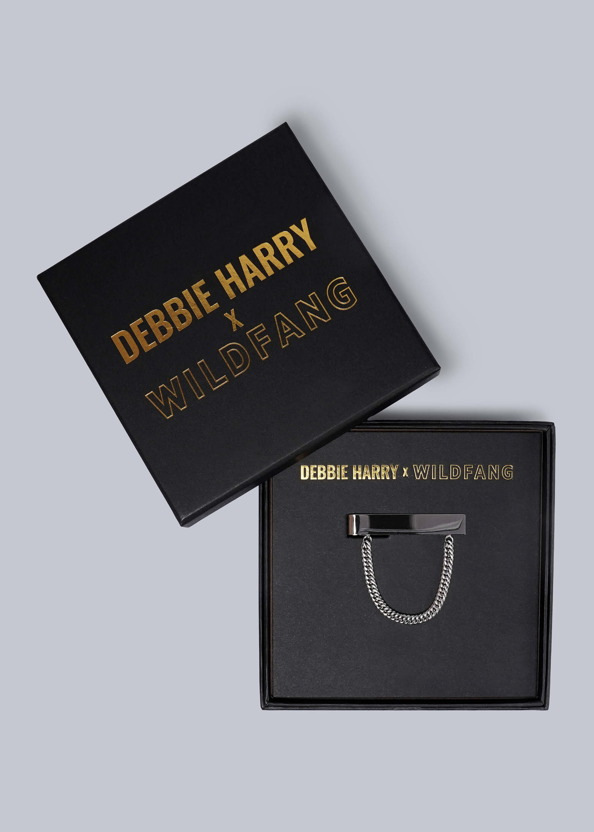 Debbie Harry x Wildfang gift box with a silver tie clip on a light gray background