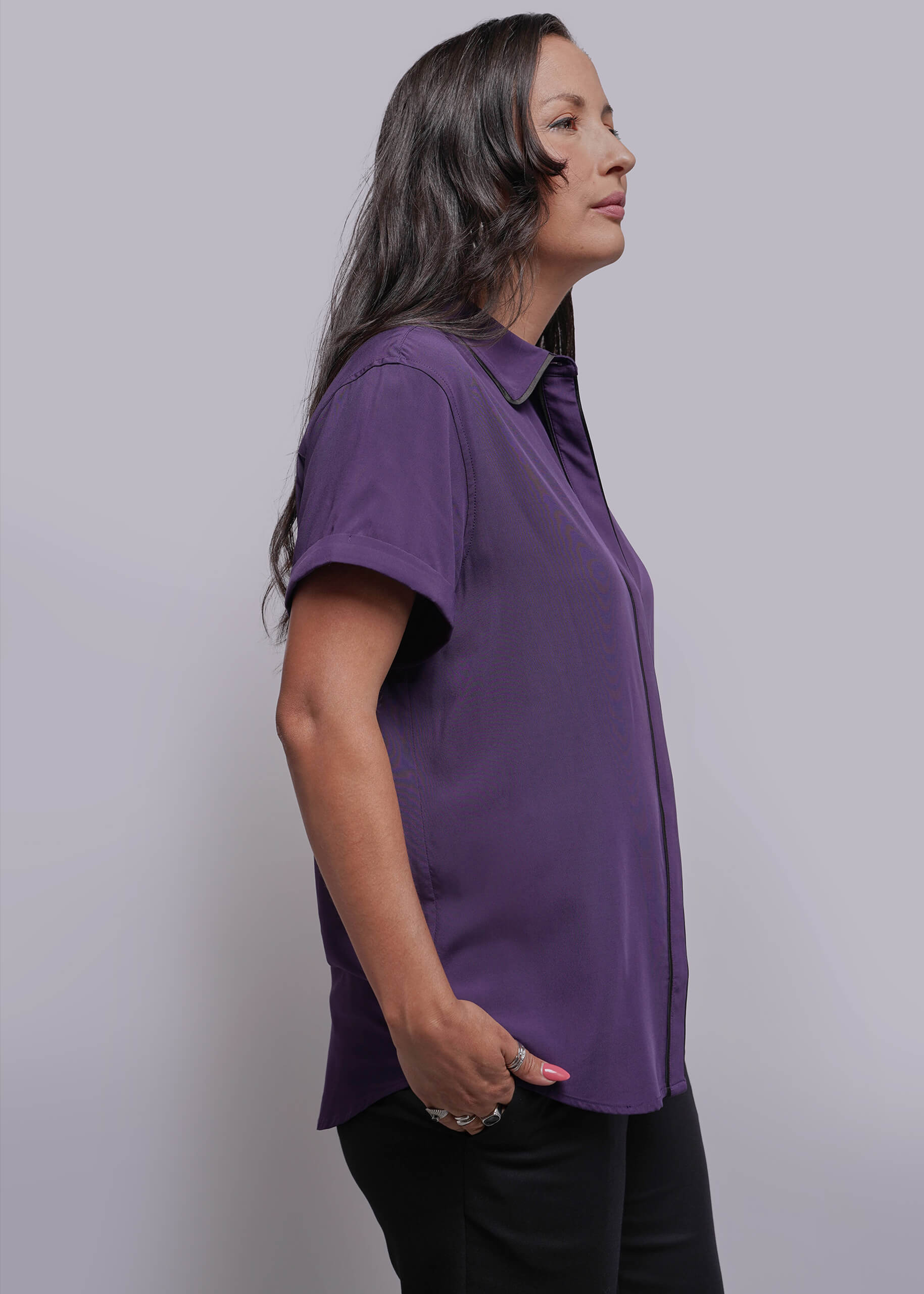 S=Woman wearing a purple shirt against a plain background