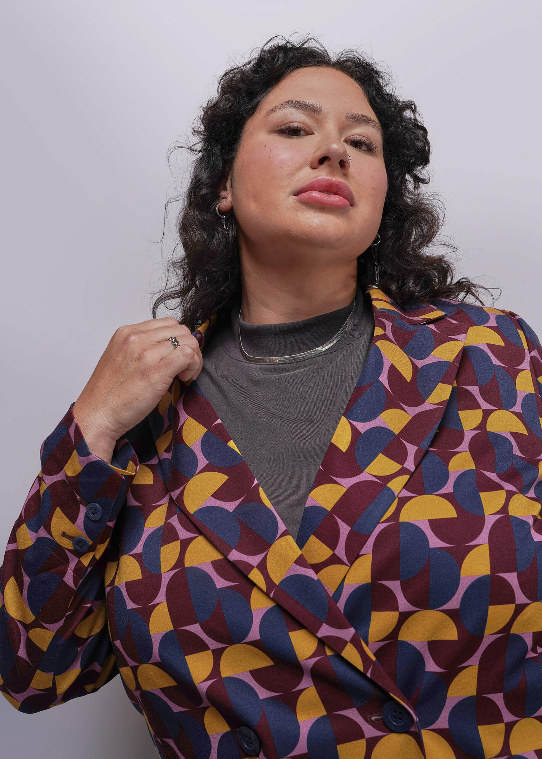 1X-Person wearing a colorful geometric-patterned jacket against a plain background