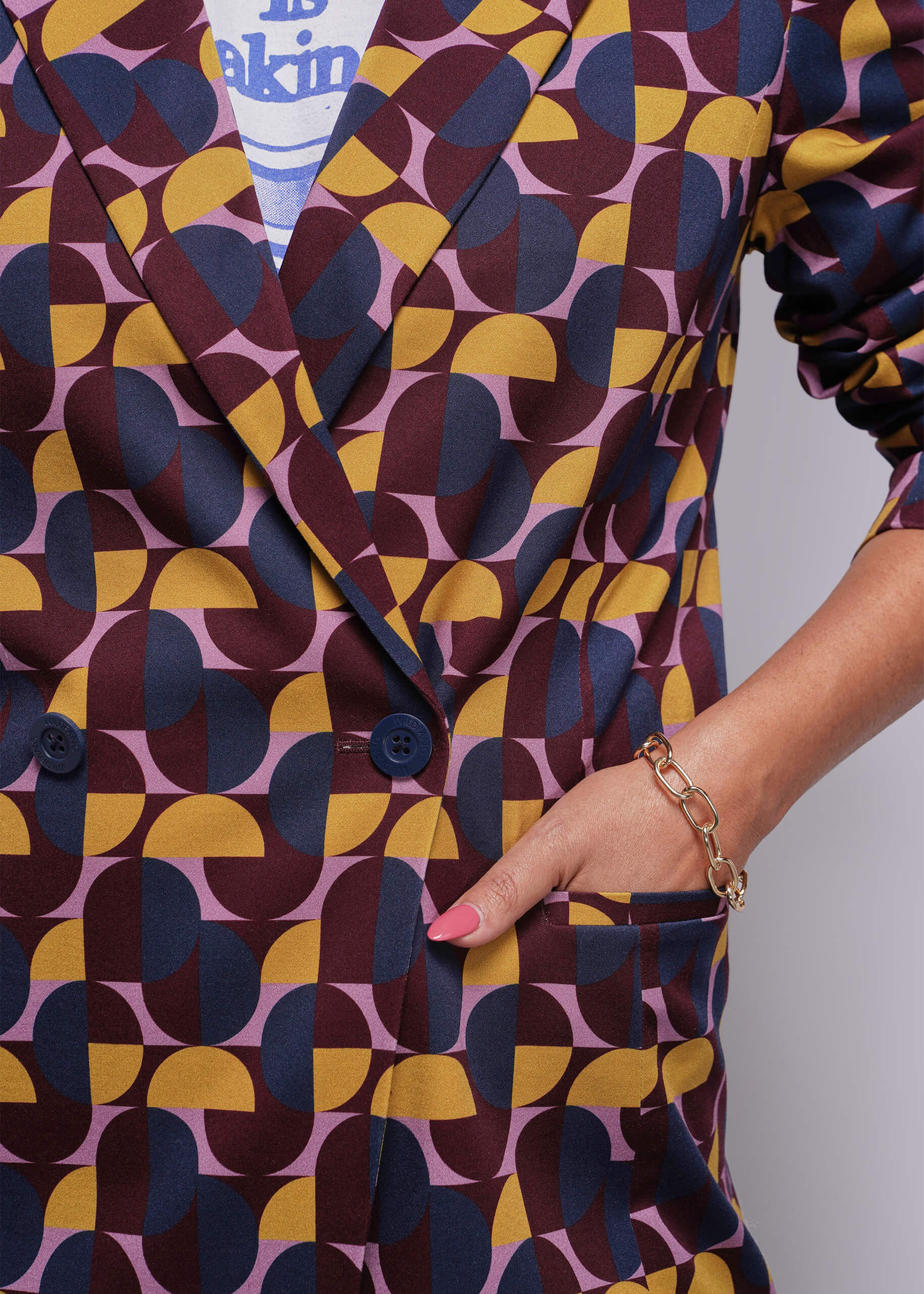 Patterned outfit with geometric design in purple, yellow, and blue on a plain background