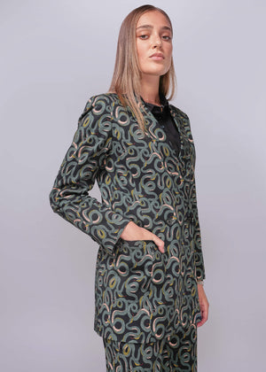 S=Woman wearing a patterned suit against a plain background