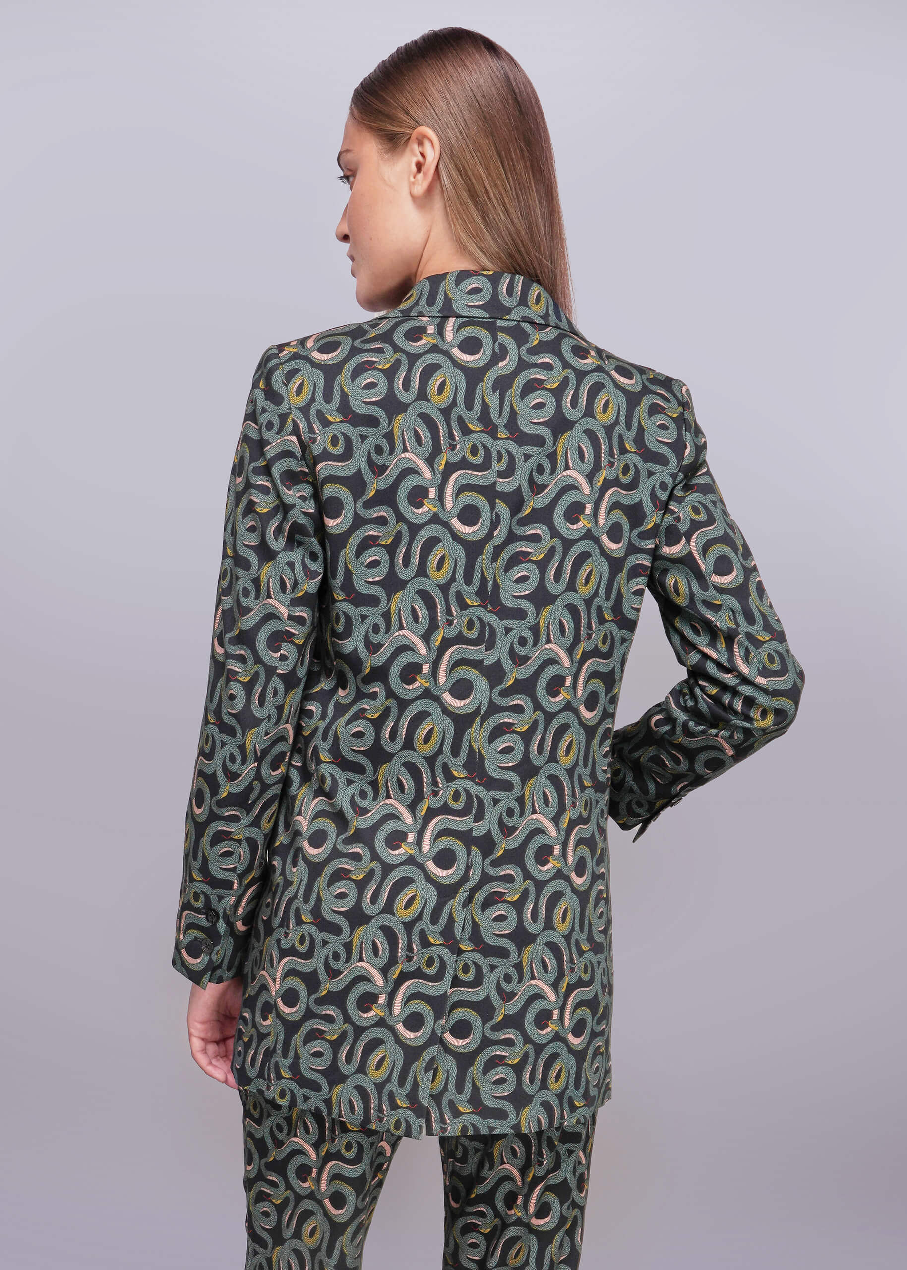 S=Person wearing a patterned blazer and pants on a plain background