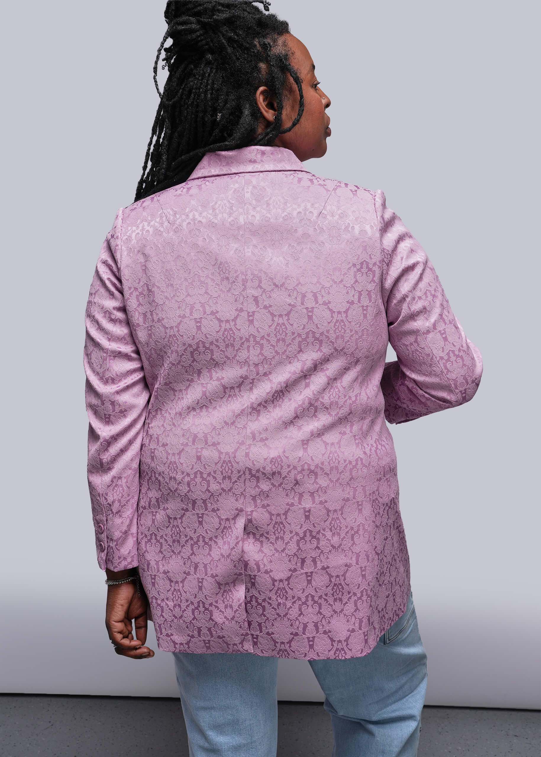 1X=Person wearing a pink patterned jacket against a plain background