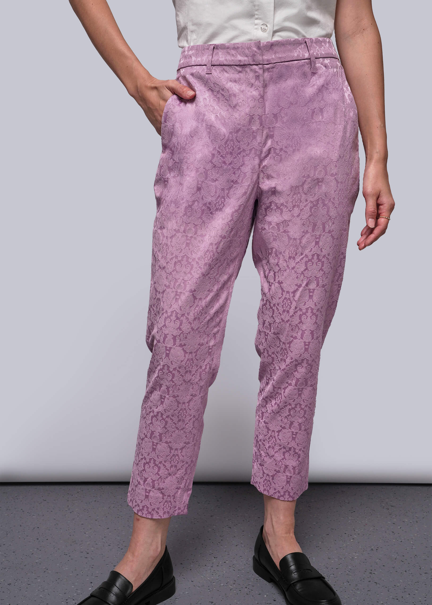 Person wearing pink patterned pants on a plain background