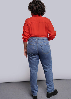 1X=Person wearing a red shirt and blue jeans from behind on a plain background