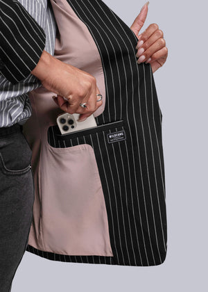 1X=Person holding a black pinstripe blazer open with a visible brand label on a light gray background