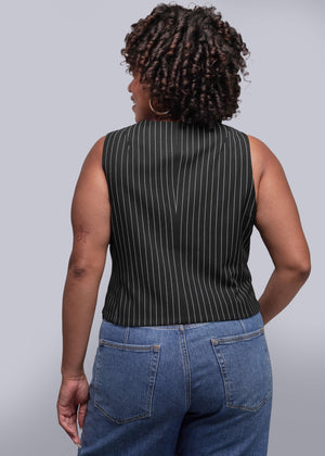 1X=Person wearing a black pinstripe sleeveless top and blue jeans against a plain background