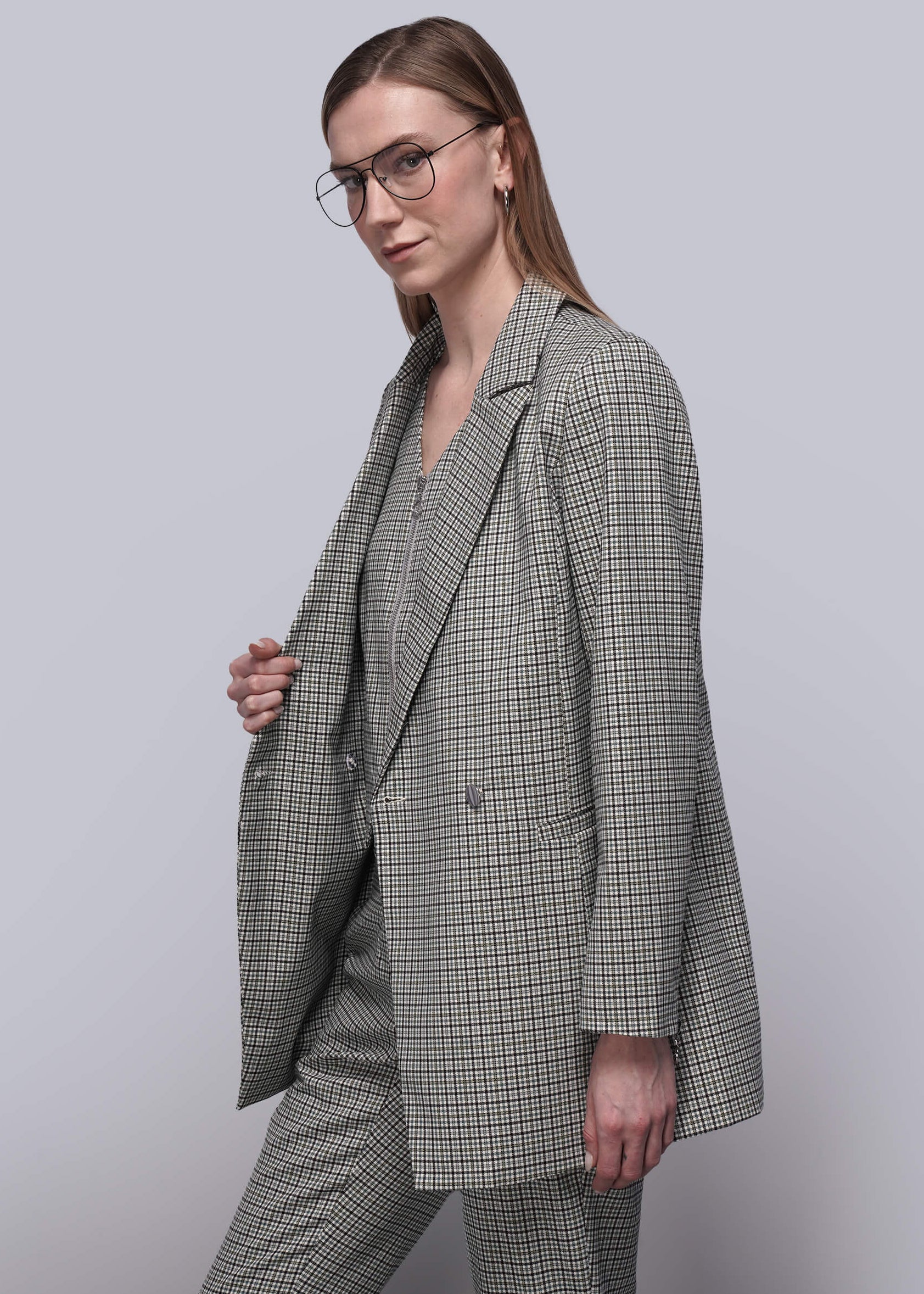 S=Person wearing a plaid suit against a plain background