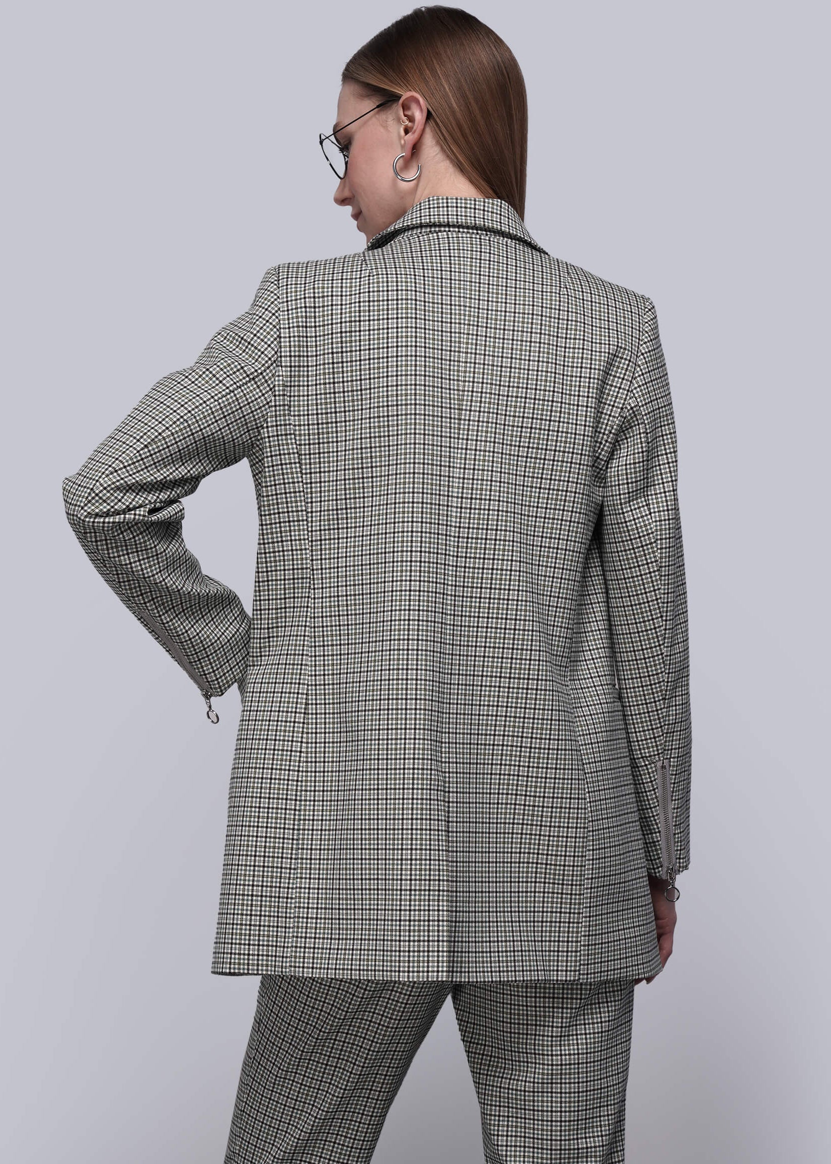 S= Back of person wearing a gray plaid suit against a light gray background