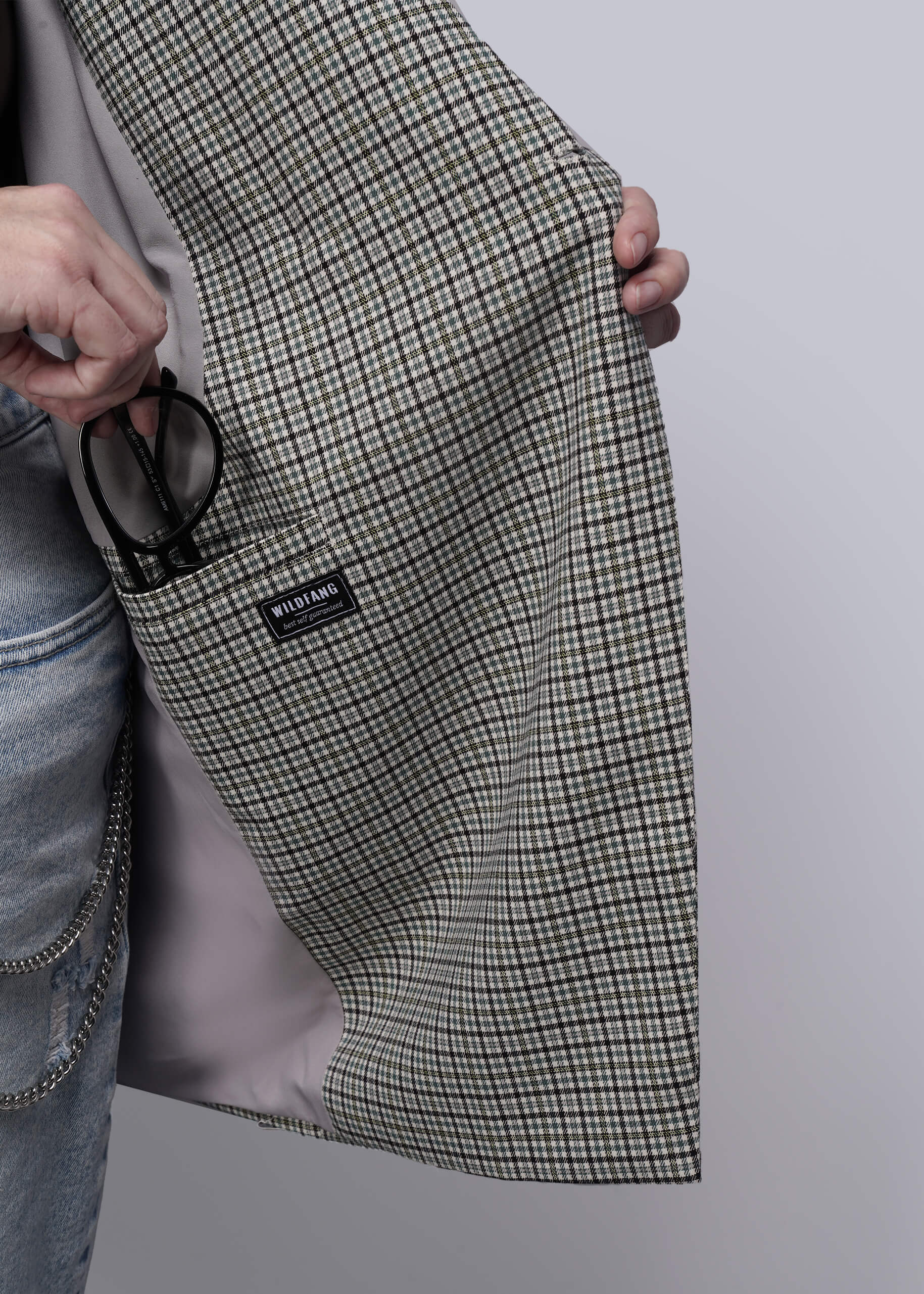 1X=Person holding a plaid blazer open with a visible brand label on a plain background