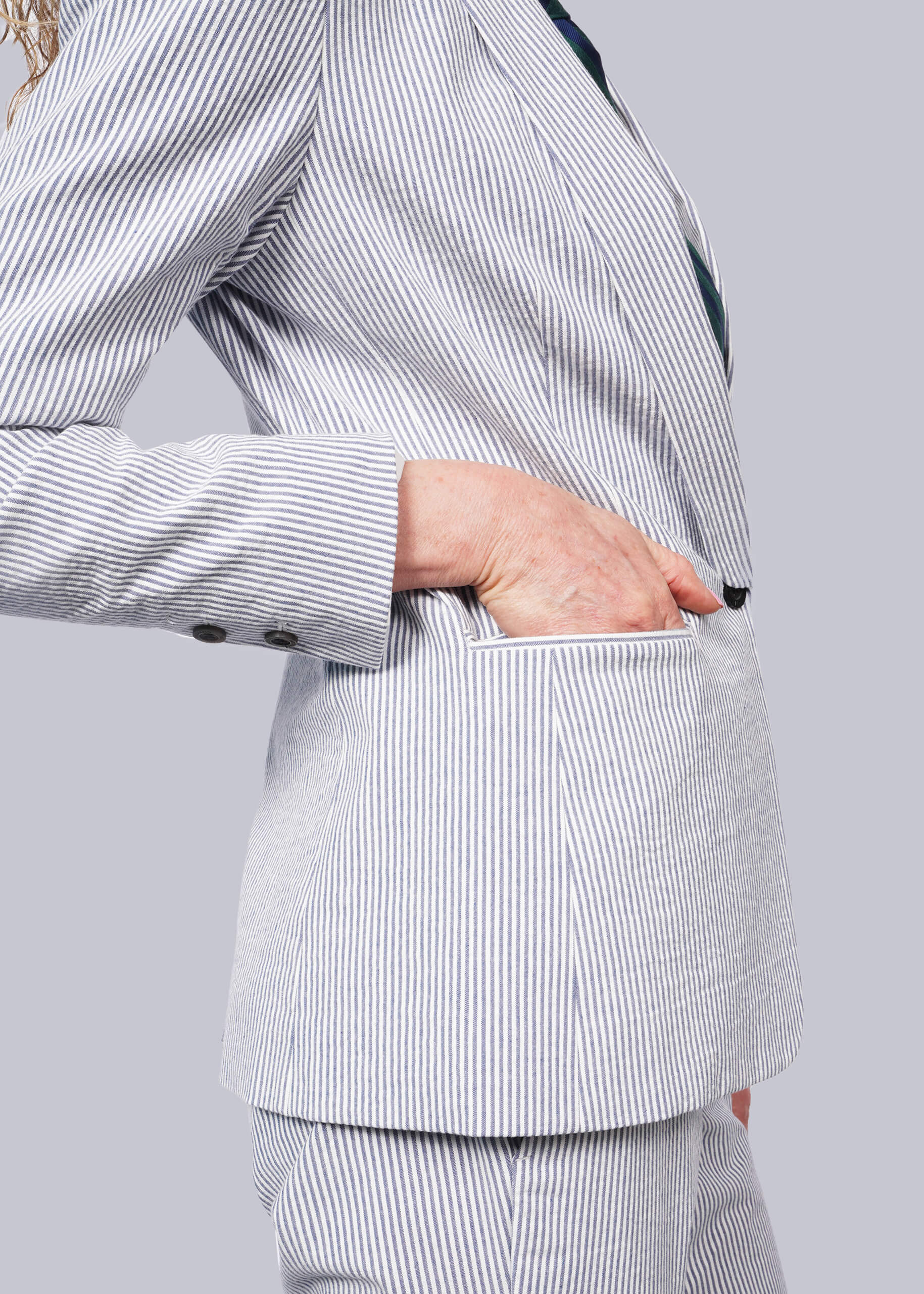 S=Person wearing a blue and white striped suit with a plain background