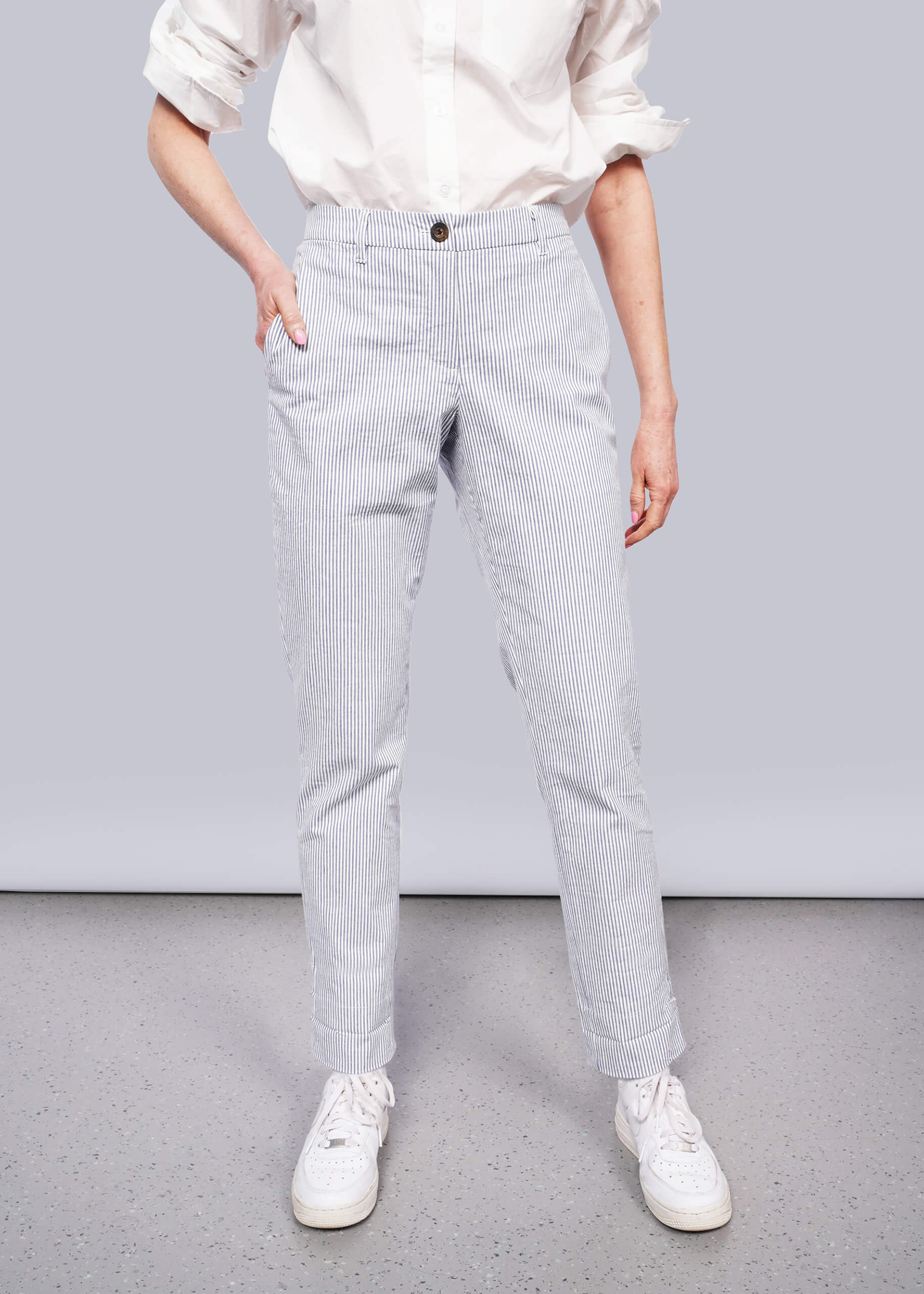 S=Person wearing light blue striped pants and white sneakers on a plain background
